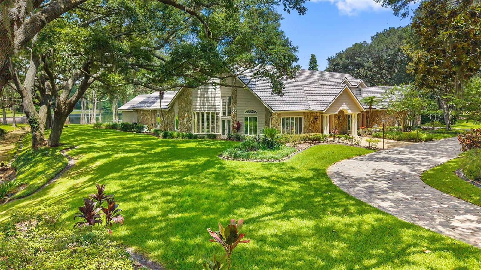 Welcome to 16310 Avila Boulevard, a rare opportunity to own one of the most exceptional single-story estate properties within Avila Golf & Country Club, Tampa Bay’s premier guard-gated luxury community.

Set on an extraordinary 1.23-acre waterfront homesite overlooking Lake Avila, this private estate offers a combination of land, water, and privacy that is seldom available within the neighborhood. While many luxury homes can be updated or reimagined over time, the setting of this property is something that simply cannot be recreated. With expansive lake views to the rear, a peaceful creek bordering the side of the property, and no rear neighbors, the homesite creates a level of privacy and tranquility rarely found in a community of this caliber.

As you arrive, a circular driveway and mature landscaping set the tone for what lies beyond. Designed around a resort-style screened PebbleTec pool and spa, the home embraces indoor-outdoor living with nearly every major living area capturing beautiful views of the water, pool, and surrounding grounds. The backyard feels like a private retreat, complete with lush gardens, a koi pond with a stone waterfall, expansive entertaining areas, an outdoor kitchen, and a setting that invites you to slow down and enjoy the beauty of the property.

Spanning 4,922 heated square feet, this thoughtfully designed estate features 5 bedrooms, 5 full bathrooms, and 2 half bathrooms, including a detached guest/pool house with its own private entrance, kitchenette, full bathroom, and walk-in shower. Whether used for guests, multigenerational living, a private office, fitness studio, or creative space, the guest house provides flexibility rarely found in today’s market.

Inside the main residence, soaring ceilings, extensive crown molding, upgraded windows and sliding glass doors, and timeless architectural details create an elegant yet comfortable living environment. The spacious primary suite offers a private retreat, while the secondary bedrooms provide exceptional comfort and privacy for family and guests.

Additional features include a metal roof, fireplace, 26KW Generac whole-house generator, 4-car garage, saltwater pool, upgraded windows and doors, and beautifully maintained grounds throughout the estate.

Residents of Avila enjoy 24-hour guarded security, roving patrol, controlled access, and optional membership opportunities at the prestigious Avila Golf & Country Club, featuring championship golf, tennis, fitness facilities, fine dining, and a premier country club lifestyle.

In a community known for luxury estates, it is rare to find a property that offers this much land, this much privacy, and such a remarkable waterfront setting. 16310 Avila Boulevard is more than a home it is one of Avila’s most unique and irreplaceable estate opportunities.
