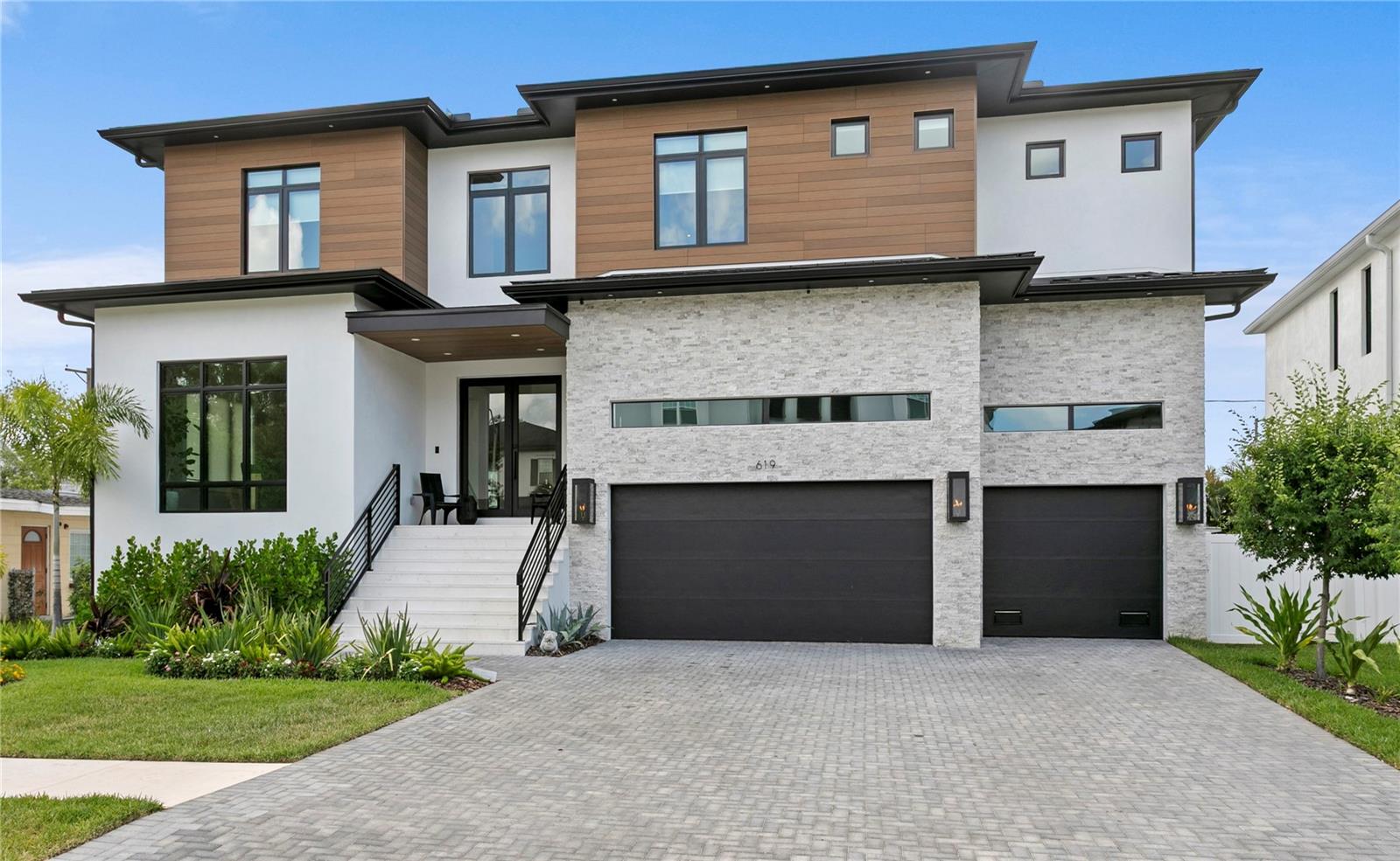 Located on spectacular Davis Islands, this newer construction home completed by BayWalk Custom Homes blends exceptional craftsmanship, sophisticated design, and expansive living spaces across more than 7,300 square feet of total living space, including 5,684 heated square feet. Built with all-block construction and completed at the end of 2024, this 5-bedroom, 5-bathroom pool home with an oversized 4-car garage, office and large bonus room, is truly one of a kind. From the moment you enter, soaring foyer ceilings and designer finishes set the tone for the thoughtfully designed open floor plan. The first floor features a spacious guest suite with private bath, a large media room, formal dining room, wine room, and an expansive great room anchored by a gas fireplace. The gourmet kitchen is designed for both everyday living and entertaining, showcasing Thermador stainless steel appliances, a 48-inch built-in refrigerator, double oven range, stone countertops, oversized island with dinette seating, walk-in pantry, butler’s pantry, and an adjacent breakfast nook. Pocket sliding glass doors flood the home with natural light and seamlessly connect the indoor living spaces to the covered lanai and outdoor kitchen. A functional mudroom and secondary downstairs laundry room add convenience just off the garage entry. Upstairs, an open loft and dedicated office provide additional flexible living space alongside three secondary bedrooms, each offering private en-suite baths and walk-in closets. The luxurious primary suite features a spa-inspired bath with a freestanding soaking tub, oversized shower with rain head, and a generous walk-in closet. Additional highlights include a large upstairs laundry room with cabinetry and sink, wide-plank wood flooring throughout, beautiful wood cabinetry, marble finishes, and 10-foot ceilings throughout. This home is located in the highly sought-after Plant, Wilson, and Gorrie school districts with close proximity to Davis Islands Village, Tampa General Hospital, downtown Tampa, Tampa Riverwalk, and Water Street. An exceptional opportunity to own newer construction in one of Tampa’s most coveted neighborhoods.