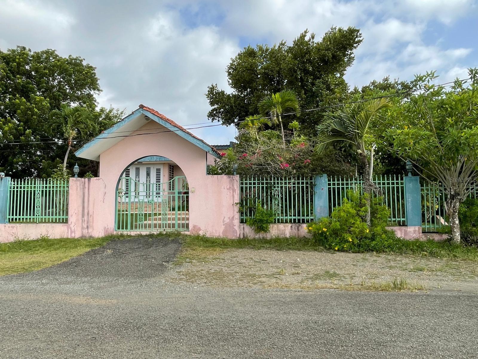 Custom-built home featuring exceptionally spacious and comfortable living areas with partial ocean views, nestled atop a hillside in Guayabo Ward, Aguada. This concrete residence offers approximately 3,042.75 square feet of interior living space on a generous 2,707.0290-square-meter (0.69-acre) lot, providing privacy, functionality, and an exceptional setting.

The home features 3 bedrooms, 2 full bathrooms, and 2 half bathrooms. Approximately 10-foot ceilings and impressive 9-foot glass windows fill the interior with abundant natural light while enhancing airflow, creating bright, open, and inviting living spaces.

The kitchen, featuring granite countertops and a breakfast area, flows seamlessly into the formal dining room and living room, creating an ideal layout for everyday living and entertaining.

The primary suite features a private sitting area, a walk-in closet, an en-suite bathroom with a Jacuzzi tub, and a private balcony overlooking the city. Additional highlights include a family room, an interior laundry room, two balconies, a sunroom, and multiple areas where you can enjoy the refreshing breeze and partial ocean views.

On the lower level, you'll find an oversized garage with space for 2 to 3 vehicles, a half bathroom, and a storage area, all accessed through a spacious driveway with an electric entrance gate.

The grounds are enhanced by mature fruit trees that provide shade, privacy, and a peaceful natural setting. Additional features include a stainless steel water cistern and a backup power generator. The two electric garage door openers are installed but are currently not operational.

With approximately 29 years of construction, this residence offers a solid concrete structure and excellent potential to be updated and customized to suit the style and needs of its next owner. As part of its deferred maintenance, the property requires roof sealing and exterior/interior painting, providing an excellent opportunity to refresh its finishes while preserving the quality and durability of its concrete construction. Given its size, layout, and location, the property may also appeal to buyers considering a hospitality or short-term rental venture, subject to applicable regulations.

Located on a quiet cul-de-sac with no HOA, just 4 minutes from Pico de Piedra Beach and close to restaurants, shopping, and entertainment, this property offers an outstanding combination of space, tranquility, comfort, and convenience.