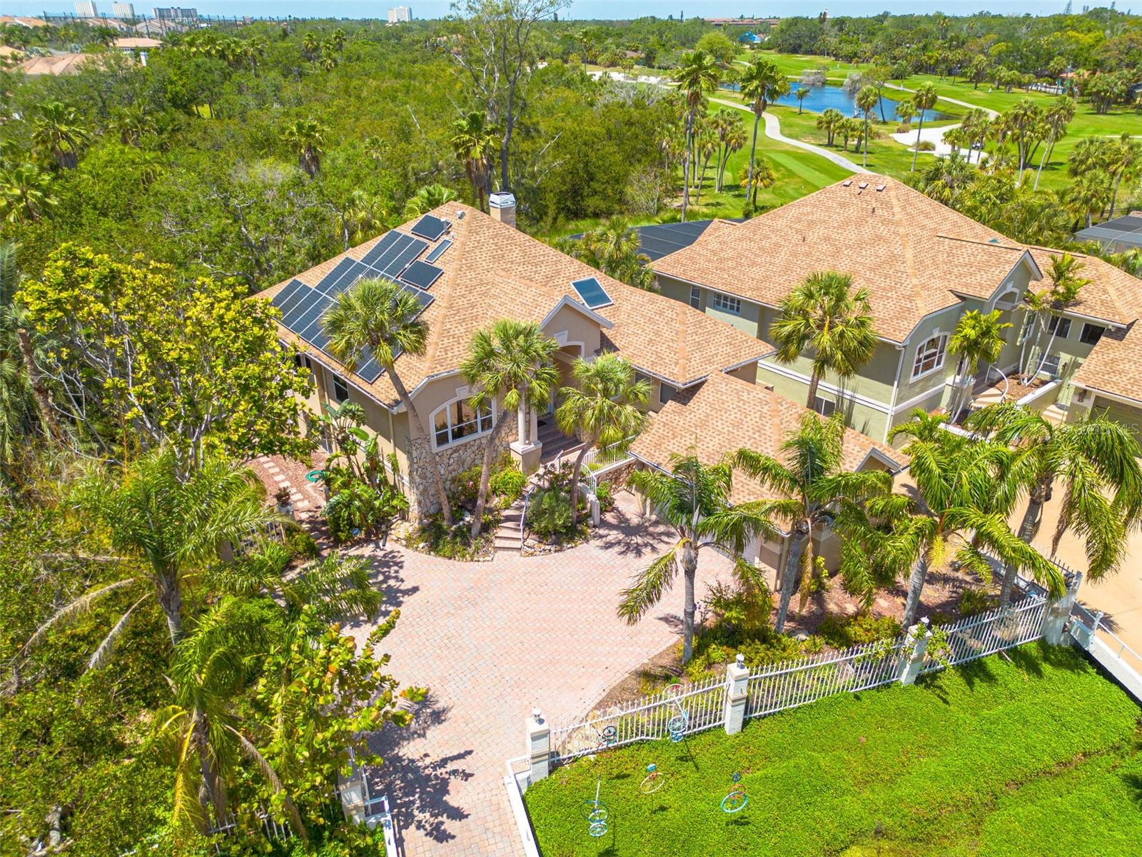 Welcome to a NATURE-INSPIRED retreat, CUSTOM BUILT in 1992 by its original builder-owner and designed to live in harmony with its surroundings. Sustainability and peace of mind are key features of this home, with PAID OFF SOLAR PANELS (2019) averaging under $100/month in electric costs, a NATURAL GAS system, and a 2024 Generac generator. Natural gas also powers the cooktop, fireplace, water heater, and BBQ hookup. Major updates include a 2015 ROOF and GAS WATER HEATER, plus HVAC systems (Main and Split Systems) replaced in 2019. Tucked just outside the gates of Pasadena Yacht and Country Club, this home feels peacefully secluded, surrounded by mature trees, a protected nature preserve, and park views, yet remains remarkably walkable to Gulfport Beach, Beach Blvd, the waterfront recreation center, and multiple nearby parks. With 3 bedrooms, 2 full bathrooms, and an oversized 2-car garage with an EV CHARGER HOOK-UP, the home balances beauty and practicality. Inside, soaring vaulted ceilings, custom blinds, and refined finishes create light-filled, inviting spaces. The CHEF'S KITCHEN features plantation shutters, striking live-edge granite countertops, a paneled refrigerator, a cozy breakfast nook, and convenient access to the indoor laundry room. The primary suite is a tranquil escape with a PRIVATE DECK overlooking the trees, a generous walk-in closet, and a spa-like bath with dual vanities, a garden tub, and a separate shower. The rear family room, fondly known as the "Tree House", features PANORAMIC views of oaks and orchids, a NATURAL GAS FIREPLACE, and elegant coffered ceilings. Outdoor living shines with THREE ELEVATED DECKS, including a grilling balcony off the kitchen and a spacious deck off the family room, perfect for entertaining or birdwatching. The lower level, while un-insurable, adds an additional 1,669 square feet of highly useful space. Equipped with a separate workshop, this space is ideal for your hobby gear, a home gym or create your own WINE CELLAR! Walkable. Private. Nature-immersed. This is a rare Gulfport opportunity.
