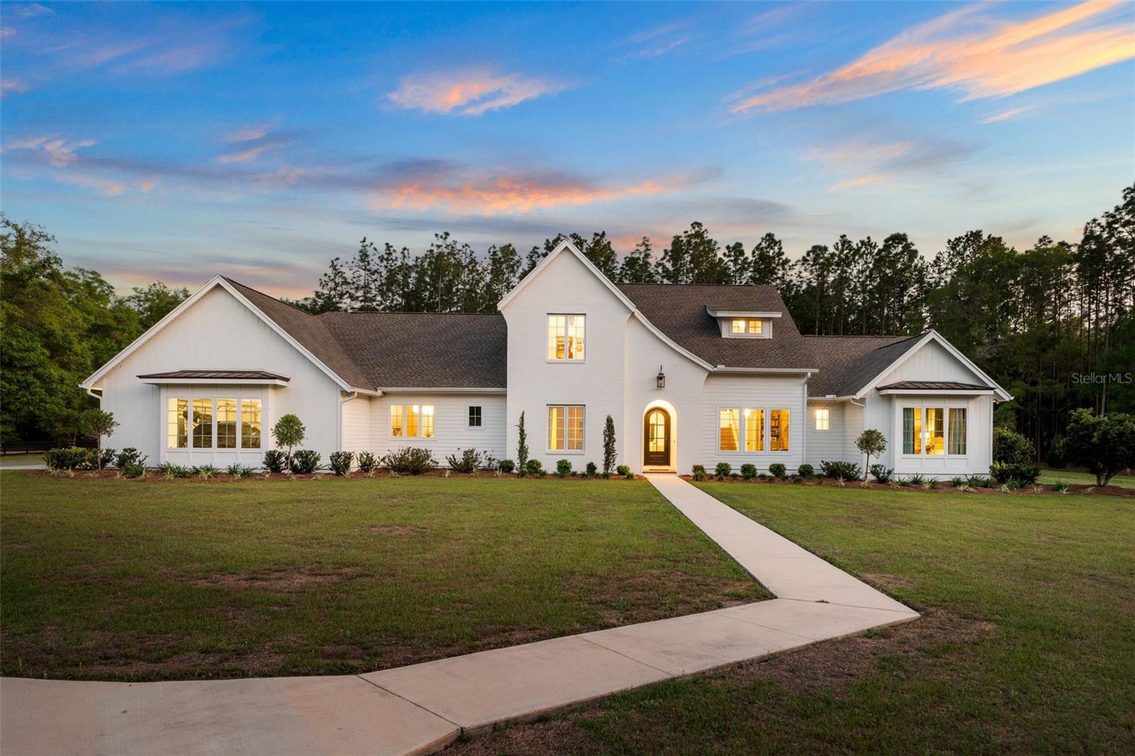 Completed in 2023, this custom-designed estate offers over 4,600 square feet of heated and cooled living space and more than 6,100 square feet under roof, set on 6 fully fenced acres within Foxridge.

From the moment you enter, the home is defined by scale, light, and architectural detail. The main living space features soaring vaulted ceilings, exposed beams, and a striking fireplace, creating an environment that feels both refined and inviting.

The kitchen is designed at a high level, featuring a fully paneled appliance suite, Dacor refrigerator and freezer, double dishwashers, a convection oven, and an ice maker. Multiple refrigeration zones support both everyday living and entertaining. A separate scullery with its own sink, refrigeration, and storage allows the main kitchen to remain clean and uninterrupted.

Thoughtful material selections include a blend of quartz, marble, and natural stone, creating depth and a cohesive, elevated feel throughout the home. Marble continues into both the primary bath and pool bath, reinforcing the level of finish across the property.

The primary suite is privately positioned on the first floor and offers a true retreat, complete with a spa-inspired bath, freestanding soaking tub, and oversized walk-in shower. The main level also includes a dedicated study and an additional office or flex space.

Upstairs, a separate wing offers additional bedrooms, a full bath, and a loft, creating a comfortable and private space for guests or family.

Outdoor living is equally impressive, featuring a resort-style pool and spa, expansive covered lanai, and summer kitchen designed to extend the living experience outdoors.

The property also includes a pole barn with both water and electricity, offering flexibility for storage, hobbies, or recreational use.

Additional highlights include a conditioned safe room with reinforced door, spacious laundry, multiple built-in waste systems, and an oversized 3-car garage.

A rare offering combining newer construction, acreage, and a thoughtfully executed design in a private setting.