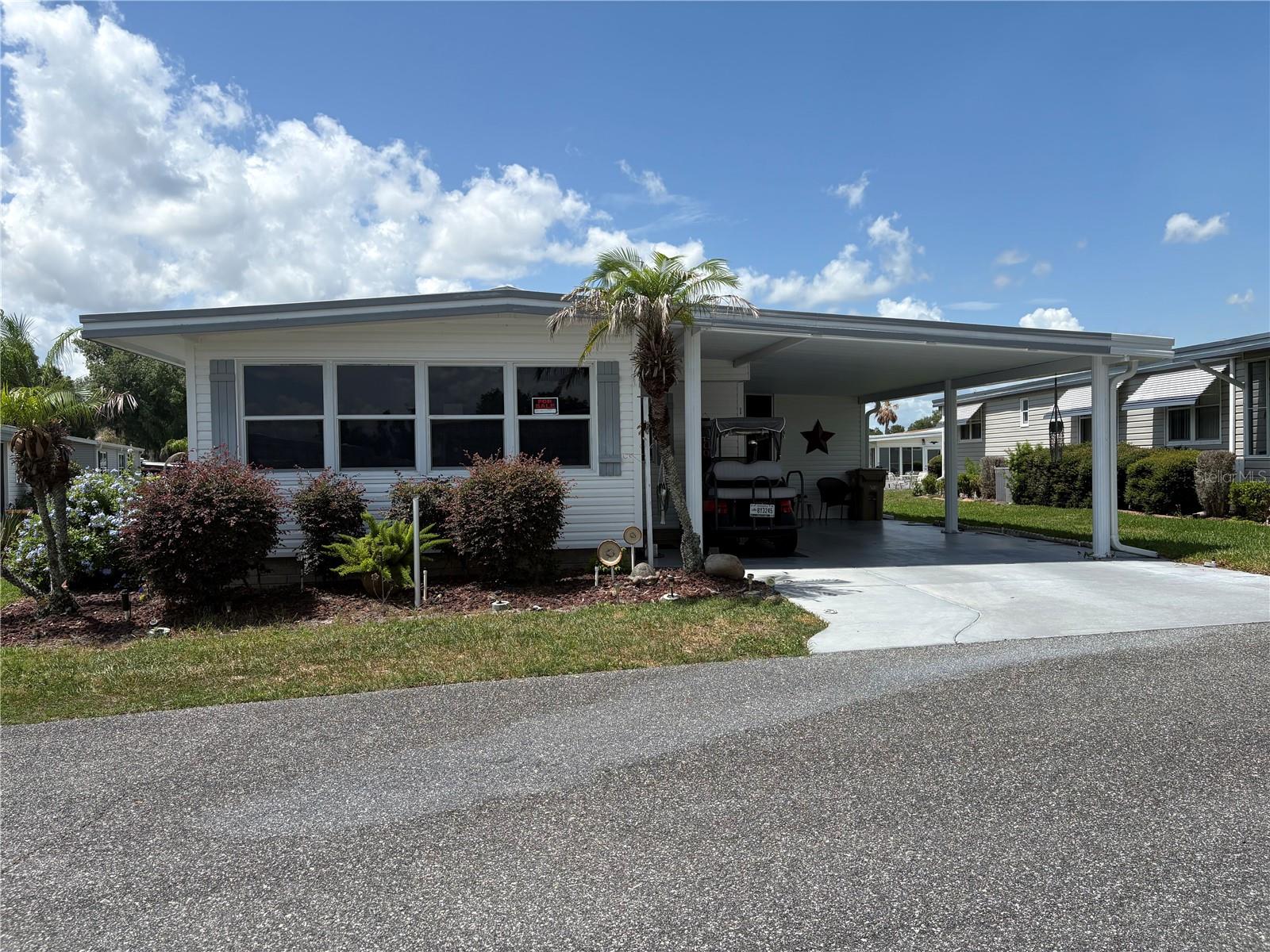 Welcome home to this beautifully maintained 2-bedroom, 2-bath residence in the highly sought-after gated 55+ community of Hawthorne at Leesburg. Situated along the western shore of Lake Harris and connected to the lake by a canal, Hawthorne offers an exceptional waterfront lifestyle with a marina featuring covered and uncovered boat slips available for lease as space permits. This move-in-ready home is being sold completely furnished, with the seller only taking a lift chair and personal belongings. Inside, you'll find a spacious dining area adjoining the kitchen, complete with a convenient breakfast bar. The comfortable living room features a newer electric fireplace and a 65-inch television, creating the perfect space for relaxing or entertaining. Stretching across the front of the home is a bright and inviting bonus room filled with natural light from numerous windows, making it ideal for a home office, craft room, or library. The primary bedroom includes an en-suite bath for added privacy and comfort. The attached Florida room offers even more functional space, including a laundry room with a new washer and dryer and a workshop stocked with a variety of tools. Two exterior storage units provide additional storage solutions. Residents of Hawthorne enjoy an impressive array of amenities, including an outdoor geothermal-heated swimming pool, two enclosed therapeutic pools, saunas, bocce courts, shuffleboard, pickleball, tennis courts, billiards, card rooms, and a full calendar of activities highlighted by the popular Hawthorne Concert Series. For added peace of mind, three emergency response vehicles are available to residents 24 hours a day, 7 days a week. Experience the active Florida lifestyle in this vibrant and welcoming community—schedule your private tour today!