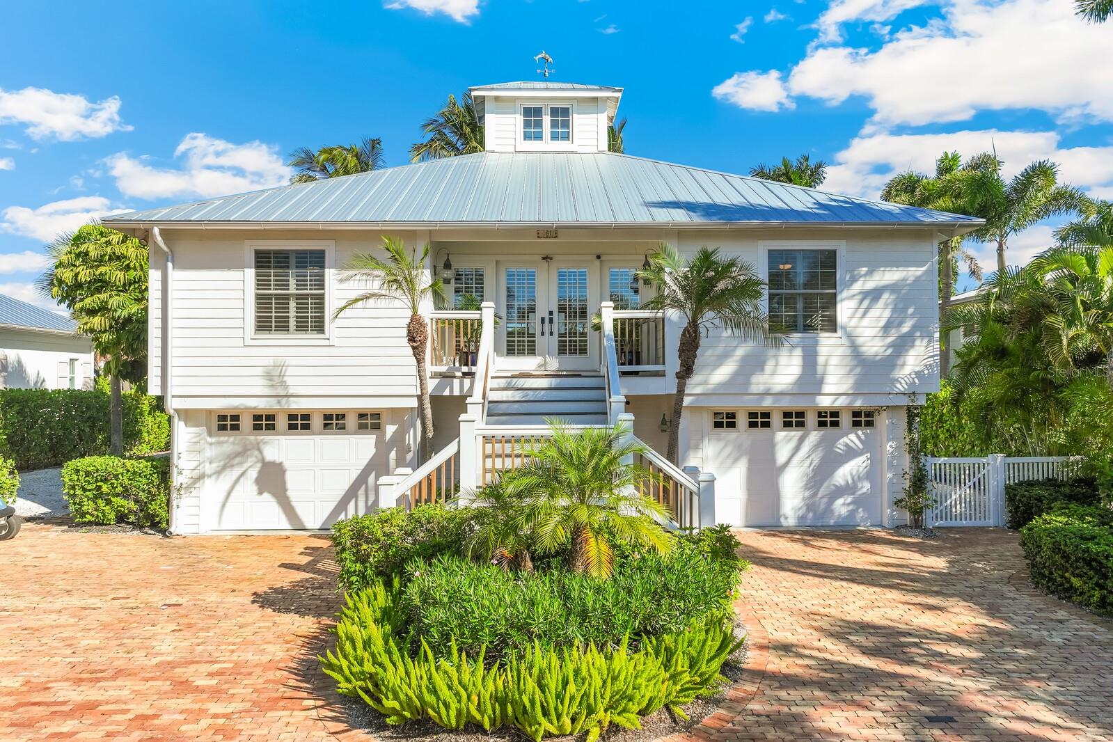 Discover this beautifully renovated cottage nestled in the Historic Village of Boca Grande, where old-world charm meets modern convenience. This 4-bedroom, 3-bathroom home spans 2,548 square feet and showcases thoughtful upgrades throughout, including a durable metal roof, Hardie plank siding, improved kitchens and bathrooms, and stunning wide plank wood flooring. 

The heart of the home features an open living area with custom wood ceilings, a cozy gas fireplace, a charming cupola that fills the space with natural light and flows to a large 335 sqft screened porch looking over the canal for true indoor-outdoor living. The primary bedroom and additional bedrooms provide comfortable accommodations, while an in-law suite with kitchenette on the lower level offers flexible living options. 

You will enjoy the lower-level outdoor living space from the shade of a covered porch or sunbathe around the custom in-ground heated pool and hot tub that create the perfect setting for relaxation. Your waterfront lifestyle includes an impressive 80-foot dock with a covered 20,000-pound boat lift on the Harbor Drive Waterways canal just steps from your back door. 

Practical amenities abound with dual garages equipped with electric vehicle charging stations, a golf cart charging station, and a convenient laundry room. The circular driveway features classic Chicago brick pavers, while mature landscaping and fencing complete the picturesque setting. 

Location is everything here – in minutes you can hop on your boat and be cruising Charlotte Harbor; or enjoy a short golf cart ride to the pristine Gulf beaches, charming shops and restaurants of Historic Boca Grande. The renowned Gasparilla Inn, exceptional golf courses, local marinas, and even Coral Creek private airport are all nearby, making this the perfect blend of peaceful retreat and convenient access to island attractions.