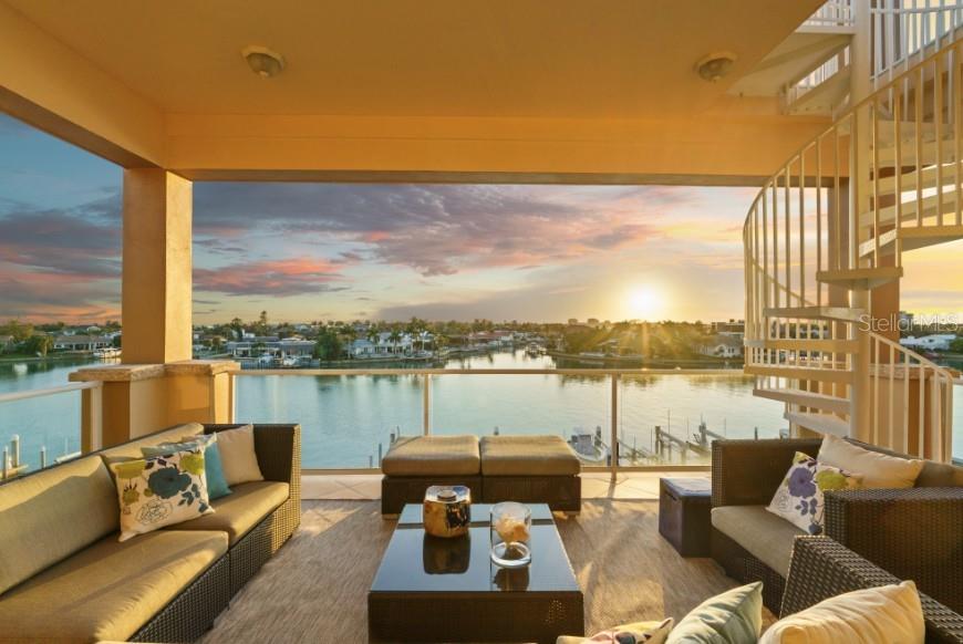 This Penthouse at Marina Pointe has a Private Rooftop Terrace and a Deeded Boat Slip! Located in the gated community of Marina Bay, The Pointe presents a collection of Boutique Condo Buildings with only three units each. This refined residence is comprised of over 3800 square feet of luxurious living area, including four bedrooms and four and a half baths. Take the elevator to your private foyer, which makes a bold statement with a ceiling to floor waterfall. Enter the open living area, surrounded by wrap around balconies, taking in southern views toward the Skyway Bridge over Tampa Bay and western views toward the horizon on the Gulf. Silk lanterns float above the formal dining area with custom mahogany built-ins to store your treasures and dramatic lighting to display your art and artifacts. The sitting room and gathering rooms are divided by a stunning three-sided gas fireplace. The kitchen is a gourmand’s sweet dream with SubZero Refrigerators, a Wolf cooktop with grill and range hood over the Center Island, double wall oven, warming drawer, ice maker and Miele barista coffee center. The breakfast bar and center island each have sinks for more prep and serving space and two dishwashers for quick clean up. Sleek custom cabinets have pull out shelves, space for spices, baking sheets and cutting boards while glass cabinets on the back of the island display barware and ceramics. A walk-in pantry is just beyond the kitchen with built-in cabinets and adjustable shelving. Of the four bedrooms, the primary suite is the showstopper. With access to the wraparound porches, enjoying sunrise and sunset views, this exquisite space is a true retreat. The primary ensuite is actually a bath and a half with two vanities, two water closets, a soaking tub and a separate steam shower. The massive walk-in closet will accommodate your entire four-season wardrobe. Two of the guest rooms have private ensuite baths, while the fourth bedroom, currently used as an office, has gorgeous etched glass doors and access to a full bath across the hall. The wine room is a sweet surprise with a glass door to gaze at your climate-controlled collection. While the interior of this home will surely impress you, the exterior will take your breath away! An entire outdoor living room awaits you and your guests as you flow from the gathering room to the great outdoors. A spiral staircase leads to your private rooftop terrace, complete with an outdoor kitchen, gas grill, built-in seating and panoramic water views! Peer down at your deeded boat slip and plan your next fishing trip or sunset cruise! This Stunning Penthouse Residence also features 11.5’ ceilings, solid wood doors, wired sound system, custom blinds and window treatments, LED lighting, impact glass windows and doors, laundry room with sink and cabinets, a large storage room, 2 mechanical closets, whole-house generator, central vacuum and a private garage large enough for three vehicles.  Marina Bay amenities include a heated pool and spa, fitness center, club house and marina. Located just off of Interstate 275 and the Pinellas Bayway, the community is ideally situated between Downtown St. Petersburg and the Gulf Beaches.  Just thirty minutes from international airports and professional sporting arenas.