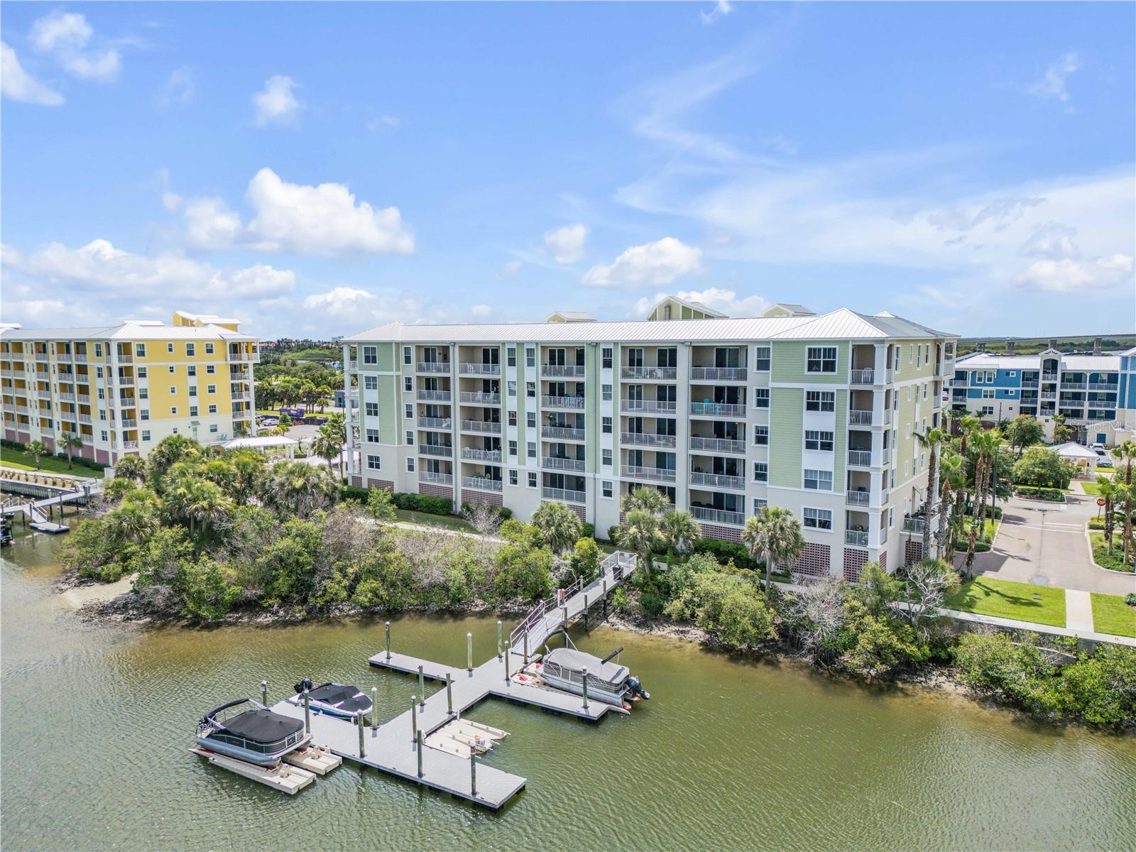 Welcome to coastal living at its finest in the heart of New Smyrna Beach. Riverwalk is a premier waterfront gated community that allows you to walk, bike, or take your golf cart to local festivals, the farmers market, dining, shopping, and of course, our beautiful beach just minutes away. This upgraded 3-bedroom, 2-bathroom condo blends comfort, style, and a relaxed coastal feel throughout. The two guest bedrooms are located at the front of the home, along with a spacious guest bathroom enhanced with custom shiplap for added charm. The kitchen is a standout feature, offering a large bar that seats four, upgraded appliances, new wall accents with added lighting, and convenient pull-out drawers in both the pantry and foyer closet. The dining area includes a built-in feature wall that adds warmth and character to the space. The main living area opens to a large screened-in balcony overlooking the Intracoastal Waterway, providing a peaceful setting to enjoy stunning sunsets and gentle coastal breezes. The primary bedroom also offers sliding glass doors to the balcony and serene water views. Its ensuite bathroom includes dual sinks, a walk-in shower, and a relaxing jacuzzi tub, creating a spa-like retreat at home. This Unit is in the middle of the Building and there are  only Five of these units in each building, one of the popular features is the large laundry room with extra storage and a built in utility sink. Riverwalk offers covered parking in an under the building garage with one assigned parking spot for each unit and kayak storage. Riverwalk offers beautifully maintained grounds, gated security, and unbeatable access to everything New Smyrna Beach has to feature. The Riverwalk Community features a beautiful clubhouse, pool, spa, fire pit, theatre room, fitness center, Bocce, Shuffleboard, Pickle Ball and Tennis. Whether you're seeking a full-time residence or a coastal getaway, this condo delivers the perfect blend of luxury, convenience, and waterfront tranquility.(HWH 2023, Dishwasher 2023, disposal 2023)