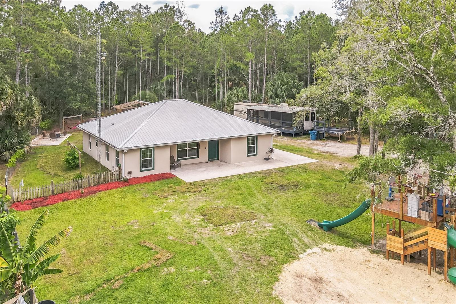 Discover exceptional country living on this 10-acre AG-zoned property in Osteen, FL featuring a modern 2018 block home with a 50-year metal roof and an impressive collection of outbuildings and improvements. Don't let the number throw you off. The 1,728 sq ft open-concept floor plan offers 3 bedrooms, 2 bathrooms, an office, walk-in master closet, walk-in pantry, and an indoor laundry room with no wasted space. Stainless appliances, granite countertops, and double paned windows will be found throughout.  The owned 500-gallon propane tank will ensure the best rates on propane (which typically only needs filling every 18 to 24 months). The gas tankless hot water heater, electric double oven (also plumbed for propane), propane cooktop, wood cabinets, wooden shelving in closets, well with water softener, RO system, and an elevation certificate provide peace of mind and long-term efficiency. The land is partially cleared with a natural tree buffer for privacy and is fully fenced, making it ideal for livestock, equestrian use, or homesteading. Two 30×40 enclosed metal workshops, both powered (one rated for a car lift), a 30x40 pole barn, plus a 20×40 lean-to (with plumbing pipes installed), offer outstanding space for equipment, vehicles, hobbies, or business use. Additional features include a pond, well house, large raised garden, chicken runs, a playground, fire pit, and a wrap-around slab perfect for outdoor living, or future screened porch/sunroom. This property has successfully supported cows, horses, goats, donkeys, and chickens --- a true multi-use agricultural setup. Located “away from it all, but in the middle of it all,” you’ll enjoy privacy and space while remaining close to Deltona, Sanford, New Smyrna Beach, Daytona, and major routes to Orlando. A rare opportunity to own a fully equipped acreage property with modern construction and exceptional versatility. Be sure to check out the virtual tour link.