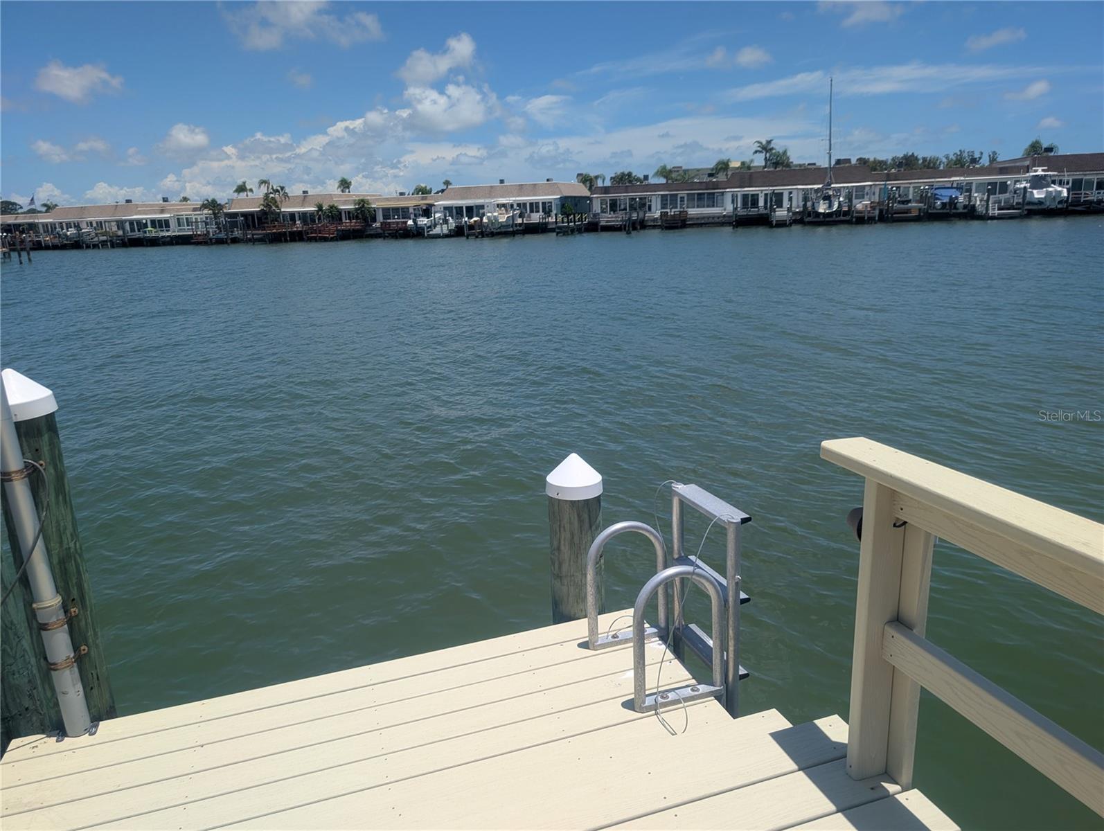 Welcome to this beautifully remodeled and move-in ready WATERFRONT 2-bedroom 2 bath VILLA with GARAGE, courtyard, private DOCK & BOAT LIFT! Nestled in the GATED 55+ Boating Community of Boca Ciega Point, this home boasts open water views, yet is located in a protected cove, ideal for boating, fishing, paddle-boarding, kayaking and dolphin & manatee watching. The new kitchen features “Lily Ann” gray custom wood cabinets with under cabinet lighting, modern back-splash, ample Quartz counter space, “Samsung” top of the line “smart appliances,” including a “quiet” dishwasher, upscale refrigerator, range, microwave and trash compactor. The primary suite includes a full bathroom, spacious walk-in shower with security handles and 2 walk-in closets, retractable blinds in lanai porch door - serene water views create a perfect spot to unwind at the end of the day. Other features include 2 skylights, ceiling fans throughout, new wood-plank laminate floors with 5” baseboards, remote-controlled sun shades in the spacious Florida room, a 3.5 ton superior “TRANE” HVAC system & water heater in 2024, double driveway, and best of all:  SEWER LINES that were SLEEVED at a cost of $12,000! Step outside and fall in love with the huge 15x11 ft composite deck, illuminated by night lights on remote control - storm-tested and built to last, for grand entertaining & fun on the water – watch the 4th of July fireworks from your backyard! An attached 1-Car Garage is finished with epoxy flooring, shelving & workbench, water softener & washer/ dryer hook-up. The monthly HOA fees cover fiber-optic cable & internet, water, sewer, trash pickup, building- and flood insurance, exterior maintenance including seawall and roof, grounds-keeping, private roads, on-site management, heated/cooled community pool, tennis- & shuffleboard courts, bocce, 2 clubhouses with active social calendar, fitness center, card- & game rooms, library, along with ENVERA – a virtual gate security system. Pet-friendly – one pet up to 25 lbs permitted (Association 14 consists of only 40 units). Short commute to Publix & Walmart stores, restaurants, bars, Seminole City Center with movie theater, St. Pete College, Seminole Rec Center, Bay Pines Marina, VA hospital, Tyrone Mall, “The Legion”, Madeira Beach #1 tourist attraction “John's Pass Village” and world-renown white, sandy beaches. The vibrant downtown of St. Petersburg is only 13 miles away and 30 minutes' drive to Tampa International Airport. This true villa-style home – no one above or below you, and resort-style living awaits you to launch into the intracoastal lifestyle – hurry – seller is MOTIVATED!