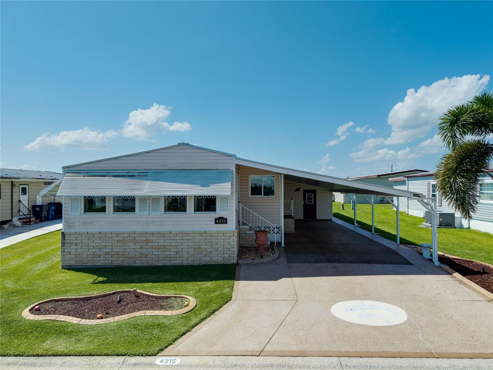 Enjoy the best of Florida living at 4215 14th St E in the highly sought-after Tidevue Estates, a vibrant 55+ land-owned community where you own the land and enjoy an active lifestyle with an incredibly low HOA of just $600 per year. From the moment you arrive, you'll appreciate the oversized covered carport offering plenty of room for multiple vehicles and the perfect space to create an outdoor seating or entertaining area. The attached storage shed features double doors, making it ideal for golf cart parking, a workshop, hobby space, or additional storage. Step inside to discover a bright, open floor plan designed for both everyday living and entertaining. The spacious kitchen is beautifully appointed with rich maple cabinetry, granite countertops, two large windows that fill the space with natural light, a convenient breakfast bar, and an appliance garage to keep everything neat and organized. The adjoining formal dining room provides plenty of space for gatherings and features a built-in china cabinet with a matching granite serving area, adding both charm and functionality. The expansive living room flows effortlessly into the light-filled Florida room, where walls of windows create the perfect place to enjoy your morning coffee, read a book, or entertain guests year-round. Vaulted ceilings and laminate flooring throughout the home enhance the open, airy feel while providing easy maintenance. The generously sized primary suite is a true retreat, featuring transom windows for additional natural light, a spacious walk-in closet, and a beautifully updated ensuite bathroom with dual granite vanities, a dedicated makeup station, and a stunning walk-in shower finished with river rock tile. Additional updates include a newly replaced carport and roof (2025), providing added peace of mind for the next owner. Beyond the home itself, Tidevue Estates offers an exceptional resort-style lifestyle with outstanding amenities, including a renovated fitness center, indoor pickleball, bocce ball, shuffleboard, water aerobics, golf leagues, and countless social activities where neighbors quickly become friends. Take a relaxing bike or golf cart ride to nearby Veterans Park to enjoy breathtaking sunsets and Florida wildlife. Conveniently located just minutes from the Ellenton Premium Outlets, dining, medical facilities, and I-75, you'll enjoy easy access to Sarasota, St. Petersburg, Tampa, and Florida's world-famous Gulf Coast beaches. If you've been searching for an affordable, move-in-ready home in a welcoming community where you own the land, enjoy incredible amenities, and embrace the Florida lifestyle, this is the one you've been waiting for. Schedule your private showing today and see everything this beautiful home and community have to offer!