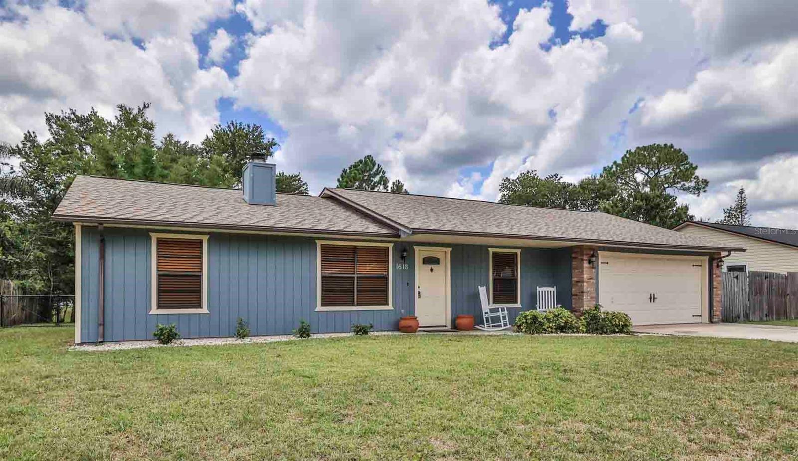 This beautifully maintained 3-bedroom, 2-bath home offers an oversized 2-car garage and an extended driveway with ample parking, including space for a boat or RV. Situated on a high and dry homesite that has never flooded, the property has been thoughtfully updated with a new roof (2024), new A/C (2024), brand-new kitchen appliances, and fresh interior and exterior paint, making it truly move-in ready. The private backyard is surrounded by mature landscaping and features a screened lanai, a charming pergola, and a paver patio, creating an inviting outdoor space for relaxing or entertaining. The fully fenced yard offers plenty of usable outdoor space, while the neighboring property to the rear sits on approximately one acre, providing a greater sense of privacy and a more open backyard setting.