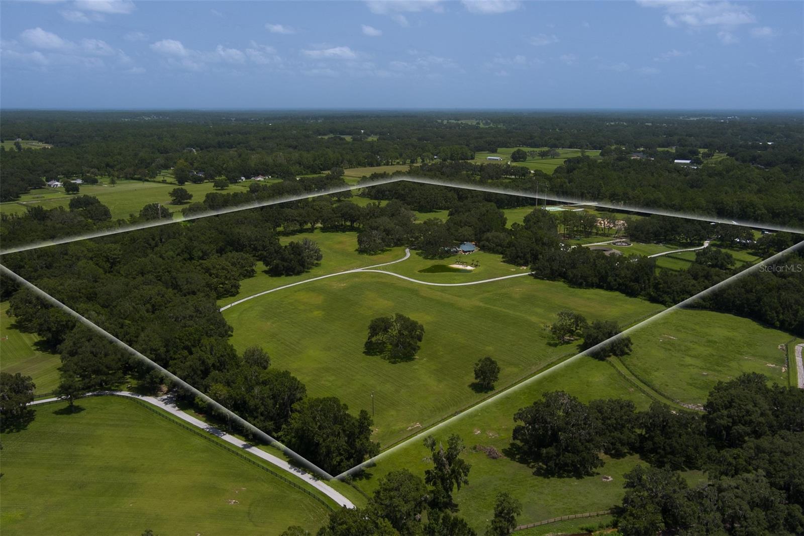 This beautifully maintained 70 acre farm, located deep in the heart of NW Ocala's horse country, has it all!  Great location?  You bet it is.  It's 15 minutes or less to shopping, dining, and the World Equestrian Center, the foremost equestrian venue in the country!  This high and dry farm is board fenced, loaded with lush green grass and majestic granddaddy oaks.  The custom 2BR/2BA home features tons of full wall windows for views in every direction, field stone accents, cathedral ceilings, fireplace, and so much more.  It has been recently upgraded with new features and fixtures, giving the entire home, especially the kitchen and baths, a whole new feel. The secondary 3 BR/2BA guest home has undergone a full makeover as well, bringing it to contemporary and modern tastes and standards.  But it doesn't stop there.  This farm also includes a CB 15-stall barn with full bath, storage, and kitchen/lounge/office.   A "pole barn" features 4 wash racks with hot/cold water, and an enclosed a/c tack/laundry/storage room.  There is an additional 4 bay pole barn for equipment and tool storage, plus a Eurosizer, and professional arena with covered viewing stand.  This gorgeous one-of-a-kind farm is an opportunity that doesn't happen often; you don't want to miss it.