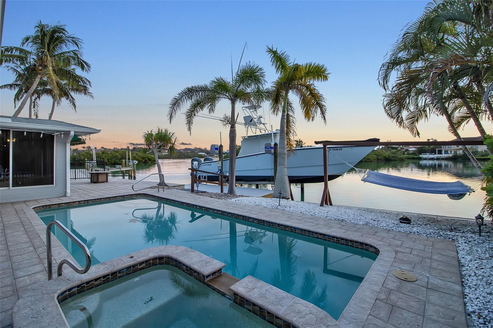 One or more photo(s) has been virtually staged. Vintage Waterfront Cottage on Casey Key. 
Quietly set on Casey Cove Drive, a private cul-de-sac just off Casey Key Road, this refreshed vintage cottage offers exceptional privacy and 180-degree Intracoastal Waterway views across Blackburn Bay. Located within a protected, minimal-wake cove, the setting is serene and timeless—where coastal breezes, open water views, and abundant marine life define everyday living.
Boating is the heart of this property. A brand-new private dock with a 20,000 lb boat lift provides deep sailboat water and generous width to accommodate a large vessel, making spontaneous days on the water effortless. Set along the Intracoastal, the home offers direct access to the bay and Gulf beyond, ideal for boating, cruising, and waterfront exploration.
Refreshed in 2024 and offered unfurnished, the two-bedroom, two-bath residence features luxury vinyl flooring, fresh interior paint, and new KitchenAid appliances. The rear living area opens to sweeping water views, creating a relaxed and inviting coastal atmosphere.
Outdoor living includes a heated pool, in-ground spa, and covered patio overlooking the water—perfect for unwinding as dolphins and manatees pass by. Just a short walk to Nokomis Beach and only one mile from the Albee Bridge, with convenient access to Venice Island, downtown Sarasota, dining, shopping, and the Legacy Trail, this peaceful waterfront cottage delivers a rare boating lifestyle in an outstanding Casey Key location.