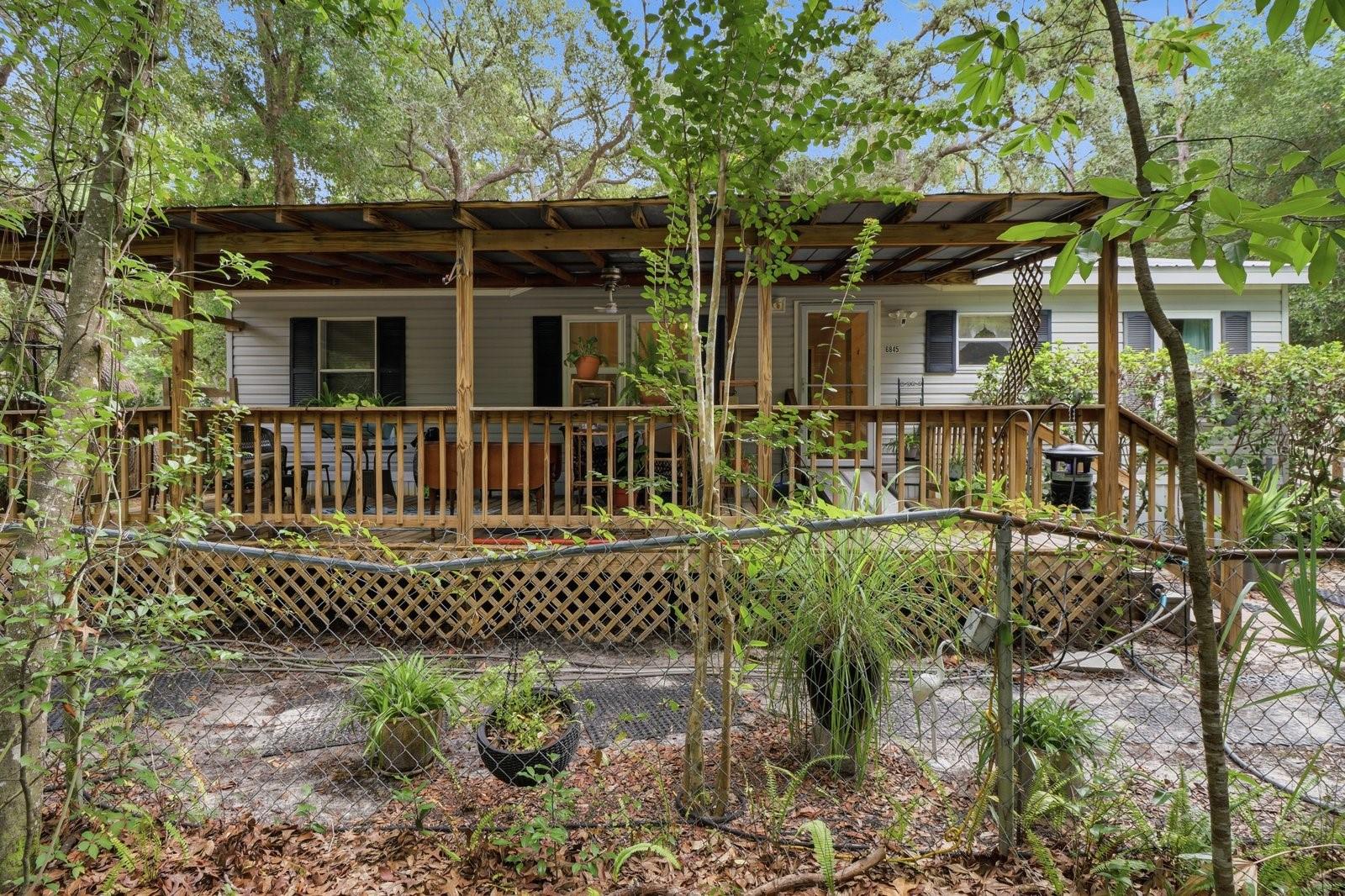 Framed by a canopy of mature trees and lush landscaping, this Homosassa retreat offers a peaceful escape while remaining close to everyday conveniences. This cottage like 2005 double-wide mobile sits on .29 acres. It is thoughtfully designed with accessibility in mind, this 3-bedroom, 2-bath home features a comfortable, easy-flow layout highlighted by a cozy fireplace, creating a warm and inviting space to relax and unwind. Enjoy your morning coffee or evening breeze from the spacious covered front deck overlooking the natural landscape, where mature trees and established vegetation provide both shade and privacy. The property also features a durable metal roof, storage shed, and a large detached garage offering plenty of room for vehicles, tools, hobbies, or recreational equipment. Located outside of the flood zone, this property provides added peace of mind while still being conveniently close to everything Homosassa has to offer. Spend your days fishing, scalloping, kayaking, or exploring the Nature Coast with public boat ramps, the Homosassa River, restaurants, and shopping all 10 minutes away or less. Whether you're looking for a full-time residence, seasonal retreat, or affordable Florida getaway, this property offers comfort, privacy, and a true taste of Old Florida living.
