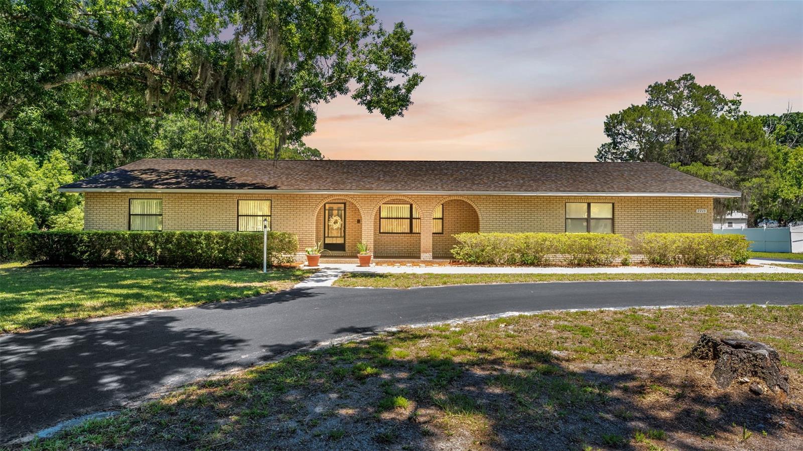 Presenting a rare multi-generational estate in North Lakeland... This exceptional property at 7715 Park-Byrd Road offers two move-in ready homes, a massive detached workshop, RV parking with full hookups, and over 2 acres of private land... all with NO HOA! Tucked away on quiet Park-Byrd Road just off Duff Road, the main residence welcomes you with charming arched front porch details and more than 3,400 square feet of beautifully maintained space (2,300 living). Inside, you’ll find 3 bedrooms, 3 bathrooms, multiple flex spaces, a formal living room, propane fireplace, baseboard heating, and a spacious Florida room complete with mini-split AC. Recent updates include a new roof (2024) and 2 new water heaters. A large screened porch overlooks the peaceful acreage, creating the perfect space to relax and unwind. Out back, the impressive 54x28 detached workshop is ideal for hobbyists, business owners, or extra storage, featuring 2 parking bays that can park up to 4 vehicles, ample electrical outlets, compressed air hookup, and a durable metal roof. Adjacent to the workshop, the RV pad includes full hookups and convenient asphalt access. Adding even more value is the fully renovated double-wide mobile home situated on the rear portion of the property. Offering 1,344 square feet, this second home features 2 bedrooms, 2 bathrooms, a screened porch, carport, and attached storage shed. The interior has been completely updated with a brand-new kitchen and island, coffee bar with stainless bar sink, new appliances, updated bathrooms, vinyl flooring, fresh drywall, and modern light fixtures throughout. Conveniently located near I-4, shopping, dining, schools, and Central Florida attractions, this truly unique property offers endless possibilities for multi-generational living, rental income, home business use, or simply enjoying extra space and privacy. Opportunities like this are hard to find, so schedule your private showing today!