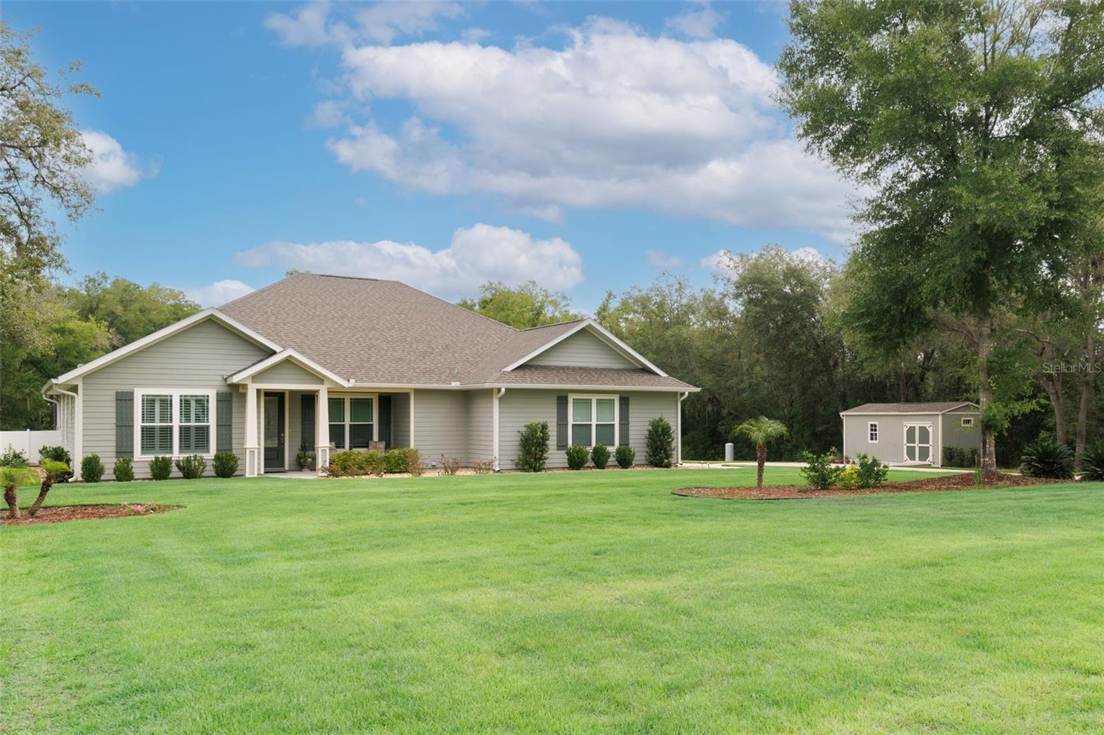 Nestled on nearly 5 private acres in low-tax Gilchrist County, this exceptional 2022 custom-built Norfleet
home offers the perfect blend of luxury, comfort, and space. Located in The Woods of Alchrist, a peaceful
61-lot community of 5-acre homesites, you'll enjoy country living just minutes from High Springs, Poe
Springs, shopping, dining, medical care, and I-75.
This 4-bedroom, 3-bath home features 2,109 square feet of thoughtfully designed living space, including a
large south-facing bonus room ideal for a home office, dining room, or flex space. The spacious primary
suite offers two walk-in closets and a spa-inspired bath with dual vanities, granite countertops, a linen
closet, and an oversized tiled shower with dual showerheads and built-in seating.
A private guest suite includes a walk-in closet, patio access, and a tiled walk-in shower. Two additional
bedrooms share a Jack-and-Jill bath and can be separated from the main living area for added privacy.
Pocket doors throughout maximize space and functionality.
The heart of the home is the expansive great room with 9-foot ceilings, 10-foot tray ceilings, crown molding,
and a stunning 13-foot granite island. The chef's kitchen features a walk-in pantry, Bosch refrigerator, gas
range, dishwasher, and built-in microwave/oven combination.
Step outside through French doors to your private backyard retreat. The screened lanai encloses a 14' x 28'
saltwater pool with cascading spa, paver decking, and 10-foot picture-window screening. A 500-gallon
underground propane tank powers the spa heater, tankless water heater, gas range, and generator hookup.
Additional upgrades include a whole-house surge protector, HVAC soft-start system, fiber-optic internet,
plantation shutters and room-darkening shades, luxury vinyl plank flooring, spacious mudroom with utility
sink, and an oversized two-car garage.
The beautifully landscaped grounds feature Zoysia grass, Knockout roses, boxwoods, Podocarpus, dwarf
mondo grass, Ligustrum, and palm trees. A matching 12' x 24' workshop/garden shed provides additional
storage and workspace.
With low HOA fees of just $8.33/month, excellent cell service, and an ideal location close to springs,
parks, and amenities, this remarkable property offers the best of North Florida living.