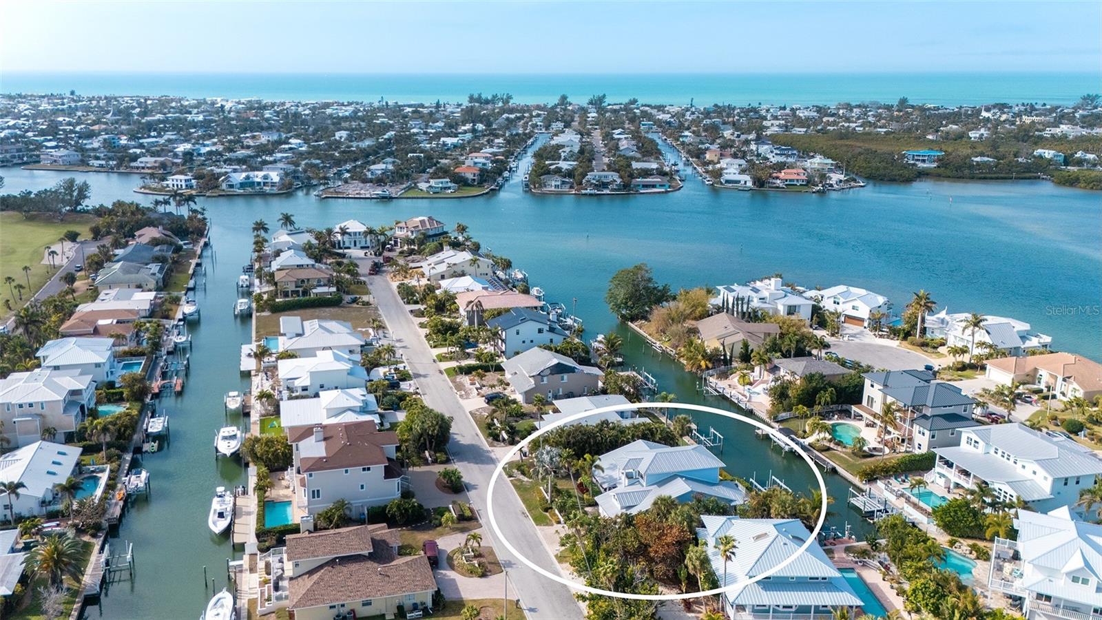 Nestled at one of the highest elevations on Anna Maria Island, this exceptional coastal retreat is located in the highly sought-after North Point Harbour community of Holmes Beach. Built in 2012 with hurricane-rated windows and doors, the home offers both refined elegance and peace of mind, perfectly blending luxury with the relaxed sophistication of island living.
A cheerful front porch welcomes you inside, setting the tone for the warmth and charm found throughout. Soaring ceilings and gleaming marble floors create a light, airy ambiance, while coastal architectural details — including multiple porches and charming balconettes — add character and dimension to the design.
The beautifully appointed living room is flooded with natural sunlight through two sets of French doors that frame tranquil canal views stretching toward Bimini Bay. These doors open to capture sunny mornings and breathtaking evening sunsets, seamlessly blending indoor and outdoor living. The open floor plan flows effortlessly into the dining and kitchen areas, creating an ideal setting for intimate family meals or hosting guests with ease.
The spacious first-floor primary suite serves as a peaceful sanctuary, complete with a lovely ensuite bath and a private deck — perfect for quiet evenings under the coastal sky. Two additional bedrooms are also located on the first floor, including a second ensuite bedroom and a third bedroom with its own bath, offering comfort and privacy for family and visitors alike.
Even everyday tasks feel elevated in the expansive and beautifully designed laundry and utility room, conveniently located off the kitchen and garage — a space so thoughtfully appointed it hardly feels like a utility area.
The entire second floor is dedicated to a spectacular private suite. This luxurious retreat features two charming balconettes, a large walk-in closet, a spa-like ensuite bath with dual sinks, and a separate office or sitting room — an ideal haven for guests or multi-generational living.
Outdoors, boating enthusiasts will appreciate the impressive 20,000-pound boat lift and expansive wraparound dock situated on a short, deep-water canal. With direct access through Bimini Bay to Tampa Bay, the Gulf of Mexico, and the Intracoastal Waterway, this property offers effortless navigation to some of Florida’s most beautiful waters.
Life in North Point Harbour is as enriching as it is relaxing. Spend mornings at the nearby Key Royale Golf Club for an early tee time, afternoons joining friends at the community pool or enjoying a friendly match on the tennis courts or padel, and evenings cruising from your private dock into Bimini Bay as the sun melts into the horizon. Here, everyday flows seamlessly from recreation to relaxation, creating a true island lifestyle defined by beauty, convenience, and connection to the water.
This extraordinary North Point Harbour residence embodies the very best of elevated coastal living — where thoughtful design, superior craftsmanship, and an unparalleled waterfront location come together to create a truly remarkable island home.