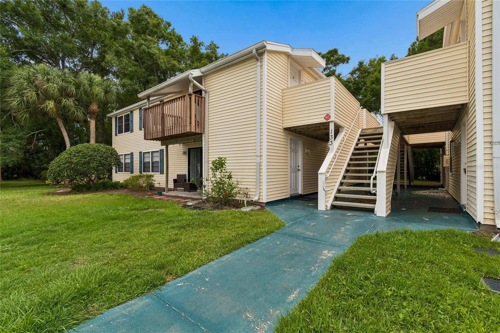 Virtually Staged. Tucked into the trees of The Gardens of Forest Lakes, this 915 sq ft second-floor 2-bedroom, 2-bath condo pairs an open-concept living and dining layout with a private deck overlooking a quiet, wooded backdrop. Laminate flooring runs throughout for a clean, low-maintenance feel, and all appliances are included for a true move-in or rent-ready opportunity. The monthly fee covers trash, exterior maintenance, exterior insurance plus access to Forest Lakes community amenities including the pool, tennis and racquetball courts, park, and playground, all set among mature landscaping. One assigned parking space conveys. With a recent rent of $1,695/month, this is a strong fit for investors or buyers seeking an affordable Pinellas County footprint. Pet-friendly with HOA approval. Ideally positioned in Oldsmar, the city with more parks per square mile than any other in Florida, with Mobbly Bayou Wilderness Preserve, Mobbly Beach Park, and the 10-mile Oldsmar Trail nearby, plus easy reach to Tampa, Clearwater, St. Pete, Gulf beaches, dining, and shopping. A smart blend of nature, convenience, and value. Note: second-floor walk-up; no elevator.