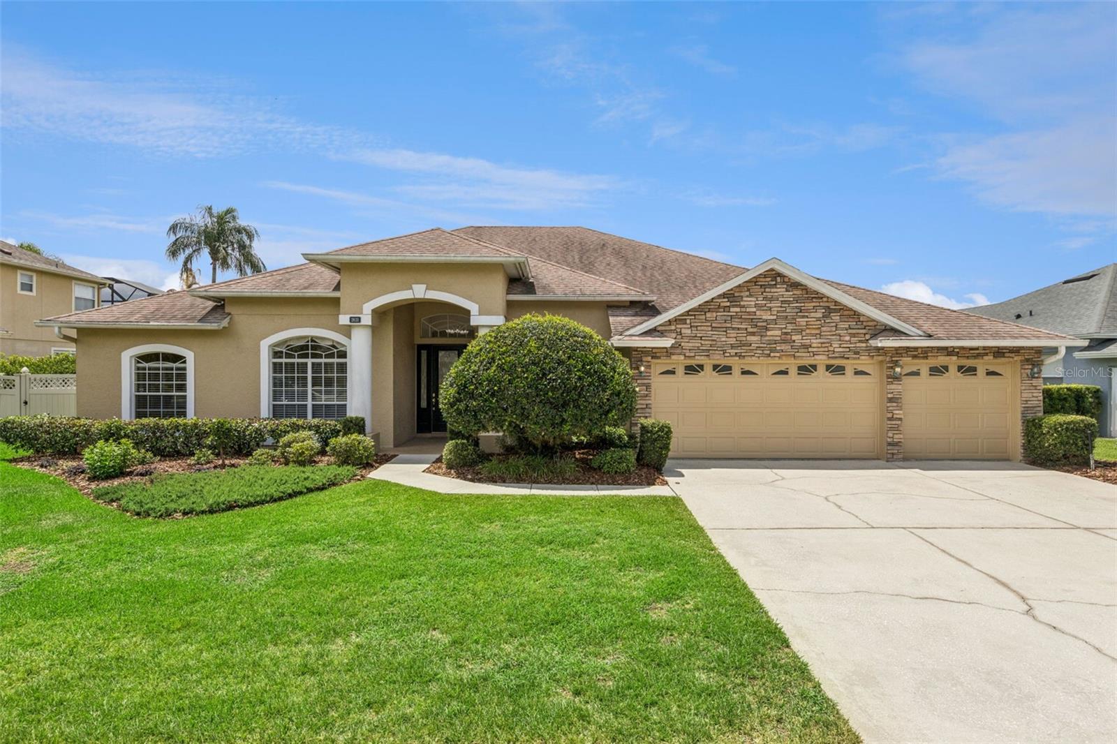 Welcome to this stunning executive home located in a highly sought-after gated Oviedo community. Situated on a beautifully landscaped and private homesite, this impressive residence offers exceptional curb appeal with stacked stone accents, a stately covered front porch, mature landscaping, and a spacious 3-car-wide driveway leading to the oversized 3-car garage.
Step through the elegant 8-foot beveled glass front door into a bright, open floor plan featuring 9-foot ceilings, crown molding, neutral colors, and abundant natural light throughout. The formal living room showcases wood laminate flooring, a tray ceiling, and a large picture window, offering versatile space ideal for a home office, library, or den. The formal dining room features wood laminate flooring, a coffered ceiling, a large window, and an elegant chandelier.
The gourmet kitchen is designed for both entertaining and everyday living with extensive workspace and storage, granite countertops, tile backsplash, under-cabinet lighting, oversized corner pantry, center island, and breakfast bar overlooking the spacious informal dining area. Stainless steel appliances include a built-in oven and microwave, Bosch dishwasher, glass cooktop, side-by-side refrigerator, and deep double-basin sink. A seamless picture window offers beautiful views of the pool and patio area.
The spacious family room features ceramic tile flooring, crown molding, a gas fireplace with built-in shelving, and oversized three-panel sliding glass doors that open seamlessly to the outdoor living area. The oversized primary suite is a true retreat offering two separate sitting areas, including one with a bay window overlooking the backyard and another with private French door access to the patio. Dual walk-in closets provide excellent storage. The luxurious primary bath includes a soaking tub, large walk-in shower, private water closet, dual vanities, built-in towel storage, and linen closet. This thoughtfully designed 3-way split floor plan provides privacy for everyone. Bedroom 4 offers a private entry hall, dual closets, and direct access to a full bath that also serves as the pool bath with patio access—creating an ideal in-law or guest suite setup. Additional guest baths feature granite countertops, including one with a tub/shower combo and another with a large glass-enclosed walk-in shower.
Additional highlights include a large inside laundry room with washer and dryer included, utility sink, upper cabinetry, shelving, and linen closet. The oversized 3-car garage features painted floors, LED lighting, pull-down attic access, side yard entry door, and two garage door openers.  Outdoor living is exceptional with a massive covered lanai measuring approximately 26x15 featuring a ceiling fan and generous entertaining space. The expansive screened pool deck measures approximately 38x28 and showcases attractive tile decking throughout, creating a true backyard paradise. The large backyard offers excellent privacy and includes a buried propane tank servicing the whole-house Generac generator.  Never be inconvenienced by a power outage again — you’ll appreciate the seller’s investment in the whole-home generator, providing added comfort, security, and peace of mind year-round. Located in a beautifully maintained gated neighborhood with sidewalks, low traffic, and generously spaced homes, this rare opportunity offers convenient access to top-rated schools, the university area, downtown Oviedo, and Winter Park.