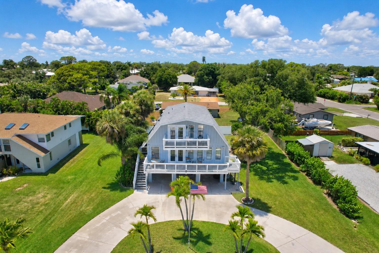 Welcome to your own Key West-inspired coastal retreat, where laid-back Florida living & waterfront adventure combine. Adding to the appeal is a DEEDED WATERFRONT PARCEL across the street, providing a rare opportunity to enjoy direct water access with the potential to build a deck, launch kayaks, or relax along the shoreline with a fishing pole. For water lovers, the opportunities are truly endless. Owners also have the option to purchase annual memberships to the South Venice Beach Ferry, giving exclusive access to a private Gulf beach & the South Venice Community Boat Ramp & Kayak Launch, giving access to the Intracoastal Waterway & Gulf waters for boating, kayaking, and fishing adventures. As you arrive home, the attractive circular driveway & two front decks create an inviting first impression. The elevated stilted design not only delivers coastal charm but also offers peace of mind, positioning all living spaces above ground level. Step inside & feel quickly relaxed within this beautiful coastal TURN-KEY FURNISHED home. Designed for entertaining & everyday living, the spacious floor plan with easy-to-clean luxury vinyl flooring, features a large, open kitchen that serves as the heart of the home, connecting the front living room & rear family room. At the rear of the home, three fully pocketing sliding glass doors open the family room completely to an incredible elevated deck overlooking the heated pool below, protected by a hurricane-strapped screened lanai enclosure. Whether you're hosting sunset dinners, enjoying morning coffee while listening to birds, spending afternoons poolside, unwinding after a day on the water or gazing at the stars, this exceptional indoor-outdoor living space creates the perfect setting! Upstairs, all three bedrooms are thoughtfully positioned to create a private retreat away from the main living areas. The oversized primary suite is filled with natural light from an entire south-facing wall of windows & French doors that open up to a private balcony, the perfect place to begin or end your day. Cathedral ceilings enhance the spacious feel, while the impressive 12 ft closet provides great storage. The primary bathroom features dual vanities & tiled shower with built-in seat. Across the hall are two additional large bedrooms, both with high ceilings & fans. A hall bathroom with a bathtub serves these bedrooms. Adding to the home's comfort & efficiency, the second floor is served by its own air conditioning system. Hosting additional guests? Easy, due to the property's 50-amp RV HOOKUP. Looking for additional storage? Find a shed at the rear of the property & a storage closet between the carports. The storage closet has electric & is water connected with the ability to install a utility sink for easy clean-up before entering your living space oasis. Thoughtfully updated for comfort & storm readiness, the home features DUAL 2-ton AIR CONIDITIONING systems installed in 2022 & they are safely elevated above ground. A new electrical panel & WHOLE-HOUSE GENERATOR PLUG installed in 2019. Additional updates include a new ROOF in 2023 with hurricane clips (insurance discounts) & a NEW WATER HEATER, POOL HEATER & WELL PUMP installed in 2024. Combining coastal island charm with modern improvements & storm-conscious upgrades, this property offers more than just a home, it offers a lifestyle centered around outdoor living, waterfront recreation, entertaining & enjoying everything Florida's Gulf Coast has to offer!
