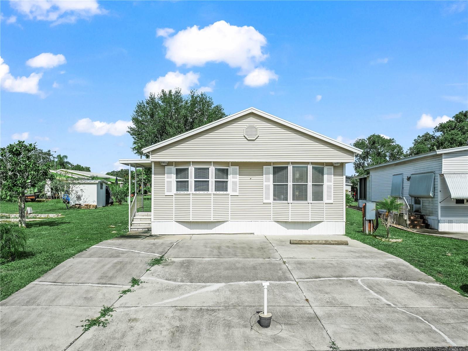 Located in the premier 55+ community of Saddlebag Lake Resort, where you own the land, this fully furnished and turnkey home is move-in ready and just waiting for its new owner!  The home has a modern feel to it, with beautiful furnishings, and is tastefully decorated with a Florida motif throughout.  Laminate flooring makes the home easy to clean and pet friendly.  The entire home is on one level, no going up and down steps after you enter.  There are two full bathrooms, one with a tub and shower combo.  An on-demand water heater was installed in 2024, for instant hot water at a fraction of the cost.  The living room is large and welcoming, and has a sleeper sofa for your overnight guests.  The spacious family room at the back of the home has a separate air conditioner for maximum comfort.  Grilling and chilling on the patio is just a step away, the perfect place to enjoy the outdoors!  When you're ready to explore the resort, you'll find plenty to do so you can stay as active as you want, and you can arrive in style in the golf cart, it's included in the list price.  Take a dip in the crystal clear pool, or relax in the screen-enclosed hot tub.  Play a game of tennis, pickle ball, horse shoes or shuffleboard.  Check out the rec room, with its pool tables and saunas, or the fitness center with its equipment to help you stay in shape.  Get to know your neighbors at the clubhouse, where you can participate in planned activities, or join a club.  The resort is pet friendly, with a dog park at the back.  There's a lakeside beach house with covered patio and full kitchen that you can use for private parties, just reserve it.  All of these great amenities are included in the low HOA dues, as well as your water, sewer and trash pick-up.  Come for the winter, or live here year round! You won't even have to leave to get your mail, there's a post office onsite.   Don't let this opportunity slip away, call now for your private tour before it's gone!