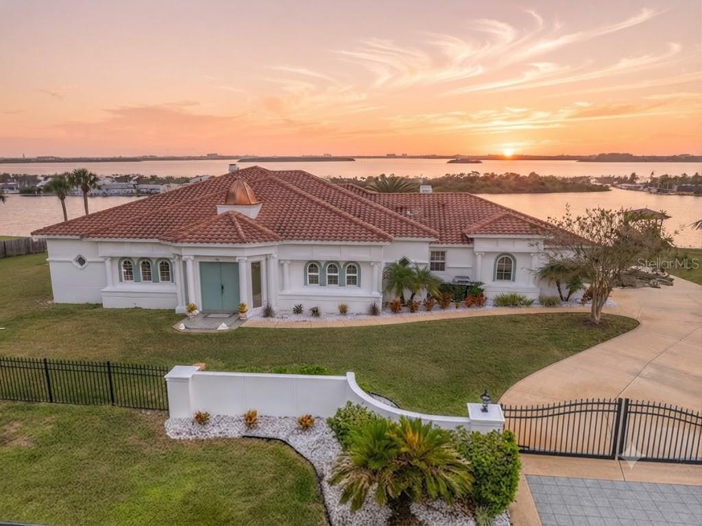 Opportunities of this scale and position are vanishingly rare along the Intracoastal Waterway. Spanning an expansive triple lot with over 240 feet of direct ICW frontage, 660 Lambert Dr offers the ultimate blank canvas for those who value privacy, and unparalleled water access.
This Mediterranean-inspired residence, with 3,476 sq ft of living space, is perfectly positioned to serve as the foundation for your ultimate coastal vision. While the home offers grand features, including a marble foyer, two fireplaces, a gourmet kitchen with dual pantries, and an expansive primary suite, the true value lies in the site itself. With an existing  pool, a newly refurbished private dock, and a gated, serene entrance, you are acquiring one of the most significant footprints in the area. Why settle for a pre-finished property when you can curate this massive estate to your exact specifications? With the bones, the location, and the space already established, this is the rare chance to own the water and build your legacy.