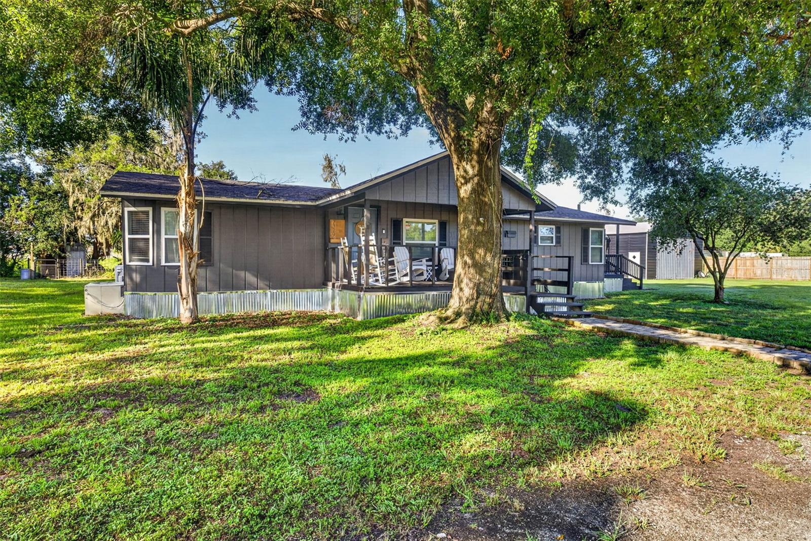 LOCATION***LOCATION***LOCATION***NO HOA***BRING THE BOAT, THE RV, ALL THE TOYS AND ALL THE ANIMALS***Welcome home to the perfect blend of country charm and modern convenience! A quaint covered front porch welcomes you inside, offering the perfect spot to enjoy your morning coffee, unwind in the evening, or simply take in the peaceful surroundings. This beautifully updated 3-bedroom, 2-bathroom home features a desirable split-bedroom floor plan designed for both comfort and privacy. The generously sized primary bedroom is privately situated away from the secondary bedrooms, creating a peaceful retreat complete with an en suite bathroom featuring dual vanities and a walk-in shower. The spacious family room serves as the heart of the home with a cozy wood-burning fireplace, while the separate dining room opens to a side porch, creating an ideal space for indoor-outdoor entertaining. Extensive updates provide peace of mind, including luxury vinyl plank flooring throughout (2026), metal skirting (2026), exterior paint (2026), freshly stained and sealed decks (2026), interior paint (2025), a new tankless water heater (2025), new refrigerator (2025), roof (2021), replacement windows (2021), a 300-foot deep well (2021), and a septic system pumped in 2021. The kitchen also features reverse osmosis water connected directly to the refrigerator for fresh, filtered drinking water.  Outside, you'll find endless possibilities with two oversized carports ideal for an RV, boat, side-by-side, or additional vehicles. A 25' x 30' metal barn with 11-foot doors and electricity provides exceptional storage or workshop space, while the high-roof storage shed offers even more room for equipment and tools. The fully fenced property is secured with a solar-powered electric gate and includes two remote clickers for convenient access to the asphalt covered driveway. The privately fenced yard is ready for your country lifestyle with a charming treehouse and an enclosed pen that's perfect for livestock, goats, chickens, or creating your own backyard homestead for fresh eggs year-round. Best of all, there's no HOA, so bring your RVs, boats, trailers, work vehicles, and animals without restrictions.This property offers an incredible opportunity to enjoy peaceful country living while remaining just minutes from I-4. Conveniently located between Tampa and Orlando, you'll enjoy easy access to world-famous attractions, beautiful Gulf and Atlantic beaches, airports, shopping, dining, and medical facilities. Enjoy the best of both worlds—a quiet country setting with everyday conveniences just a short drive away. Come see this property for yourself and take in the peace and serenity that you can soon call home!