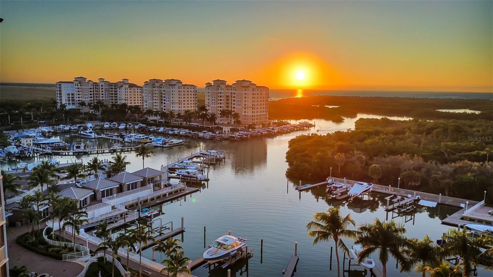 Exceptional value for a corner end residence in North Naples' premier boutique waterfront tower at AQUA at Pelican Isle. Residence 605 captures sweeping west-facing sunsets over the private marina, Wiggins Pass, and the Gulf, along with tranquil east-facing views across the fairways of Kinsale Golf Club and protected green space that will not be built upon. From your secured, semi-private elevator foyer, the 3,514-square-foot floor plan unfolds into generous living and family rooms, a formal dining area, and walls of glass that fill the home with natural light throughout the day.

The gourmet kitchen is anchored by a large island and appointed with Wolf gas cooking, Sub-Zero refrigeration, premium built-in appliances, custom cabinetry, and dedicated wine and beverage refrigeration, a true entertainer's kitchen. Wood, tile, and carpet flooring flow through three spacious en-suite bedrooms plus a private den/office, 3 full and 1 half baths, and a dedicated laundry room with Electrolux appliances and separate entry. A screened lanai with hurricane shutters extends the living space for year-round enjoyment, and an additional open balcony is ideal for morning coffee. Two fully enclosed under-building garage spaces (one with EV charger), a storage unit, and impact glass throughout complete the package.

Offered partially (mostly) furnished and move-in ready, this is an exceptional opportunity for immediate occupancy.

AQUA is an amenity-rich, low-density boutique tower offering a 24-hour attended front desk, weekday concierge, an on-site manager, a private marina with direct Gulf access through Wiggins Pass, kayaks, a waterfront resort-style pool and spa, a sky lounge, a fitness center with a sauna and steam room, a theater, a billiards and golf simulator lounge, a library, social rooms, a putting green, dog parks, and guest suites for overflow visitors. Ideally located adjacent to the Pelican Isle Yacht Club and minutes from Vanderbilt Beach, Mercato, and world-class Naples dining and shopping.
