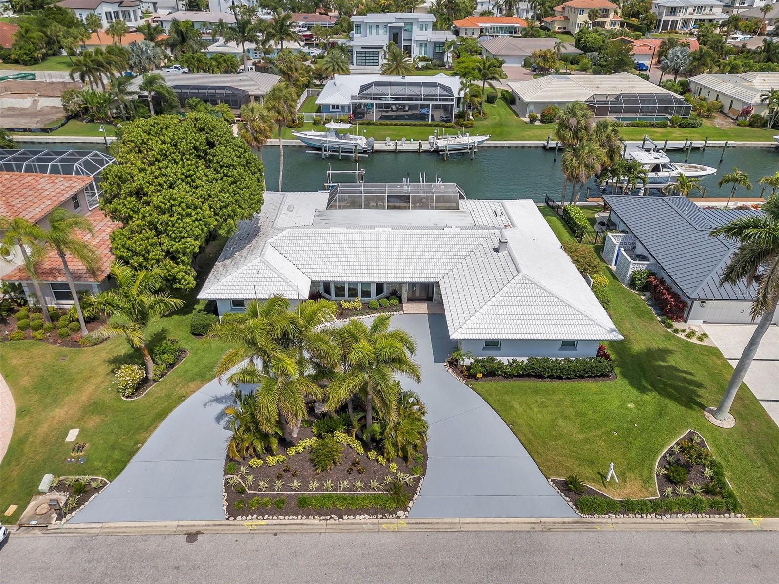 Welcome to this bright home with an open floor plan, peacefully situated along the serene Country Club Shores waterway. This spacious residence is designed for comfort and style, featuring vaulted ceilings, large bay hurricane-proof windows, and a split plan with generously sized bedrooms. The home boasts elegant limestone flooring and large sliders from the living room and bedrooms, leading to a private, screened pool area.

The kitchen is an entertainer’s delight, offering a pass-thru window and bar to the lanai, perfect for hosting gatherings. Additional highlights include a circular drive, a side-load garage, and a private dock on a deep-water canal, complete with a 10,000-lb lift and a separate jet ski lift for two jet skis. The beautifully maintained landscape enhances the home’s charm, and the recently restored seawall adds to its appeal.

With deeded private beach access just minutes away and proximity to St. Armands Circle and downtown Sarasota, this property offers a prime location and a sophisticated, tranquil lifestyle. Located in the highly sought-after community of Country Club Shores on Longboat Key, this home provides a unique blend of luxury and harmonious living.

Enjoy fishing on your dock or relaxing on the pristine beaches. This prime location is adjacent to the Longboat Key Club Resort (membership required). It provides convenient access to the shopping and dining options of St. Armands Circle and downtown Sarasota. Seize the chance to embrace the island lifestyle in this paradise setting! This home is being offered furnished, except for artwork and the piano, and is ready for you to move in and start enjoying immediately.

Schedule your private showing today to experience this beautiful property firsthand!
