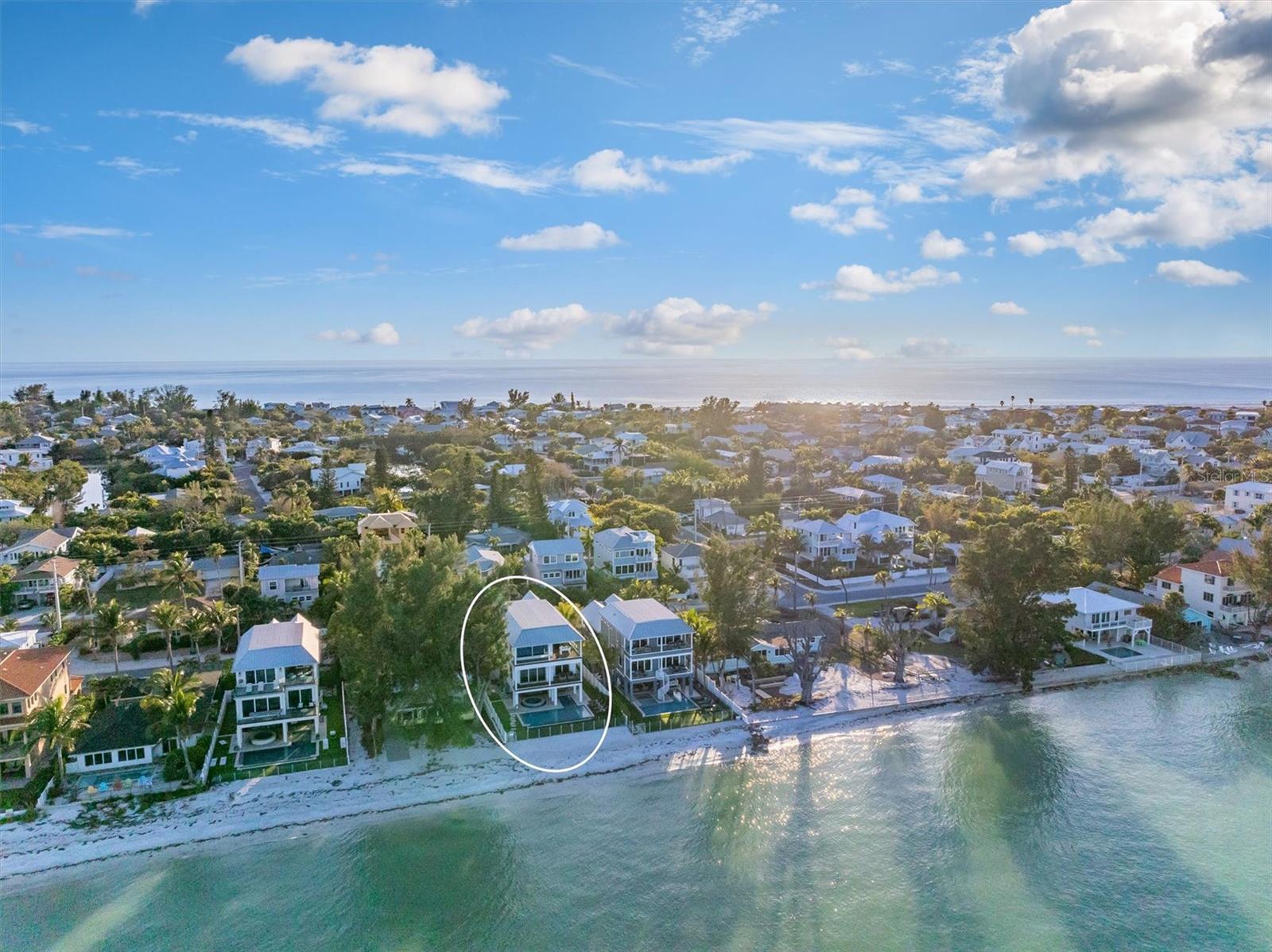 Welcome to this stunning show stopping property on the North End of Anna Maria Island very well known as Beachfront Bliss.  Enjoying panoramic views of the bay will captivate you while also having your own private beach! This 4 bedroom, 4.5 bathroom home is one of the highest producing rental properties on the north end of the island. The rental income on this property is outstanding with 2026 having $455,251 on the books thus far! The location doesn't get any better as it’s located directly on the bay, steps from Bean Point and a short stroll to the heart of Anna Maria, Pine Ave where all the boutiques and restaurants are. Unwind in the open living space, where an abundance of natural light and breathtaking views creates a tranquil atmosphere. Enjoy viewing dolphins and manatees from the plush furniture without even leaving the home!  The primary bedroom has a private balcony to capture the picturesque sunrises and breathtaking views of the illuminated Sunshine Skyway Bridge colors at Night.  While the additional three bedrooms has its own ensuite bathroom and walk-in closet, ensuring a comfortable and private retreat.  Kids (and adults!) LOVE the game room featuring classic video games to family board games and puzzles, the game room is the perfect spot for lively entertainment. Golden Tee Golf and a variety of classic games provide hours of enjoyment for the whole family.  Step outside into an expansive outdoor space designed for leisure and recreation. Lounge on the sandy beach, take a dip in the heated pool or oversized hot tub, or play a round on the putting green. The outdoor living area features a wet bar and a large Weber Genesis gas grill, perfect for alfresco dining. Enjoy the tropical oasis with outdoor Sonos speakers, an aquarium selfie wall, and various beach gear and toys. Large 2 car garage and an elevator for convenience. Being its first time on the market, this opportunity to own this unique piece of property won’t last long!