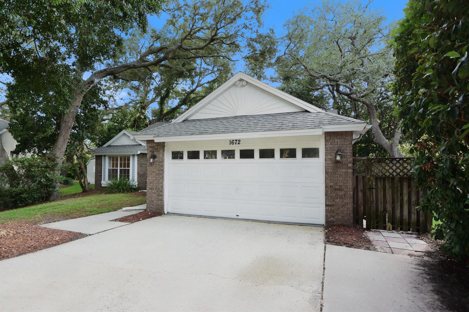 One or more photo(s) has been virtually staged. Check out this Tarpon Springs stunner located on a gorgeous tree-lined street in the highly desirable Rolling Oaks community. This beautiful home features gorgeous tile flooring, soaring cathedral ceilings, and an inviting eat-in kitchen complete with a breakfast bar. The thoughtfully designed split-bedroom floor plan offers privacy and comfort, while the spacious primary suite boasts attractive laminate flooring and a walk-in closet. An inside utility room with additional storage adds convenience, and the tranquil screened porch overlooks a shady, fenced backyard, creating the perfect setting for relaxing or entertaining. Nestled in a quiet and established section of Tarpon Springs, Rolling Oaks offers a peaceful setting while remaining close to everything that makes the area so special. Enjoy easy access to the world-famous Tarpon Springs Sponge Docks, charming downtown Palm Harbor, Fred Howard Park, and the award-winning beaches of Honeymoon Island and Caladesi Island. This is Florida living at its finest—don't miss your opportunity to call this exceptional property home.