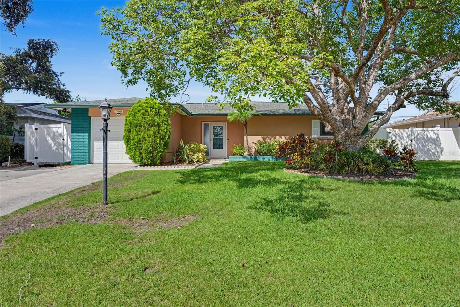 Welcome to this well-maintained 3-bedroom, 2-bathroom home in the Greenbriar community of Clearwater, offering a recently updated kitchen, a 2018 HVAC system, and a spacious driveway. This home is move-in ready and designed for everyday convenience. The open-concept living room and kitchen create an inviting space for gathering with family and friends. The beautifully updated kitchen features quartz countertops, stainless steel appliances, a farmhouse sink, floating shelves, a large peninsula with seating, and a brand-new dishwasher installed in 2026. Wood-look luxury vinyl plank flooring flows throughout the main living areas, adding warmth and durability. The spacious primary features a wall-to-wall closet and ceiling fan, while the third bedroom is equipped with a built-in Murphy bed and additional storage, making it an ideal guest room, home office, or flexible living space. The main bathroom features a tub/shower combination, and the enclosed Florida room with newer windows provides additional living space perfect for relaxing, entertaining, or enjoying the Florida sunshine year-round. For added peace of mind, the home includes a Ring Security system featuring a wired front spotlight camera, rechargeable backyard camera, rechargeable Ring video doorbell, and interior plug-in chime. A portion of the original garage had been previously converted into additional living space, providing increased flexibility. The remaining garage area still offers enough room for a golf cart, storage, tools, or convert back to a full garage, giving you the best of both worlds. Greenbriar residents enjoy a low HOA while taking advantage of outstanding community amenities, including a heated swimming pool, fitness room, active clubhouse, and a variety of social activities and events. Conveniently located just minutes from Countryside Mall, Whole Foods, popular restaurants, shopping centers, and everyday conveniences, this home also offers a quick drive to the beautiful Gulf beaches. Schedule your showing today!