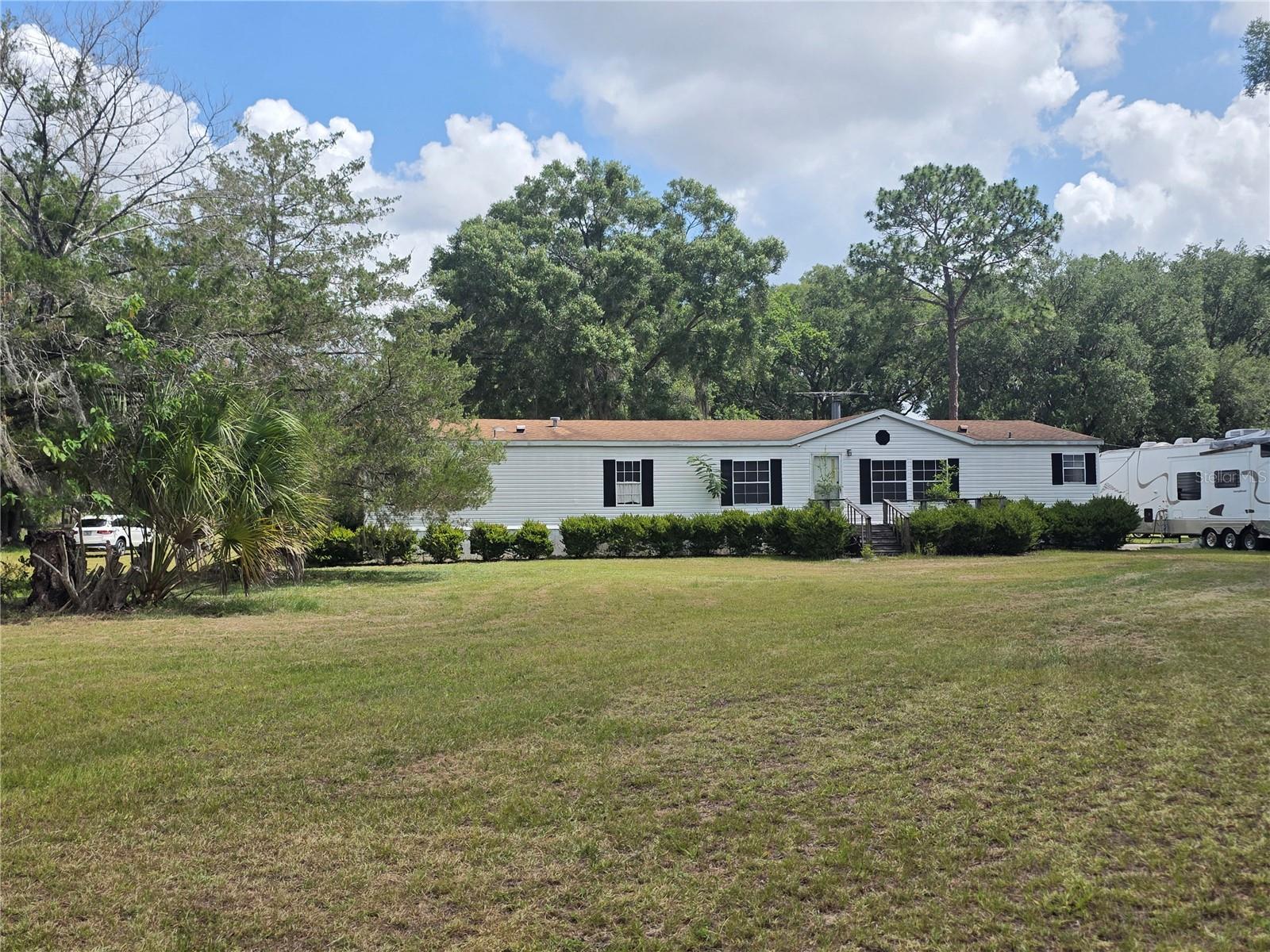 Experience the best of country living with this spacious 4-bedroom, 2-bathroom manufactured home situated on nearly 5 acres of land, conveniently located just off US 441. Offering plenty of room both inside and out, this property is perfect for those seeking privacy, space, and endless possibilities.

Inside, you’ll find a warm and inviting floor plan featuring two separate living areas, providing flexibility for entertaining, family gatherings, a game room, or a home office. The cozy fireplace serves as the centerpiece of the main living room, creating the perfect spot to relax and unwind.

Step outside and enjoy the expansive acreage, ideal for animals, gardening, recreation, or simply enjoying the peaceful surroundings. The property includes two chicken coops for those interested in homesteading and a large detached garage/workshop with ample space for tools, mechanics, storage, ATVs, motorcycles, boats, or other recreational toys.

Enjoy the tranquility of rural living while remaining close to shopping, dining, and major roadways. Whether you’re looking for a private retreat, hobby farm, or a property with room to grow, this unique opportunity has it all. Motivated sellers make this an excellent opportunity to own a slice of country paradise. *Room sizes is an approximate and must be independently measured**Schedule your private showing today!
