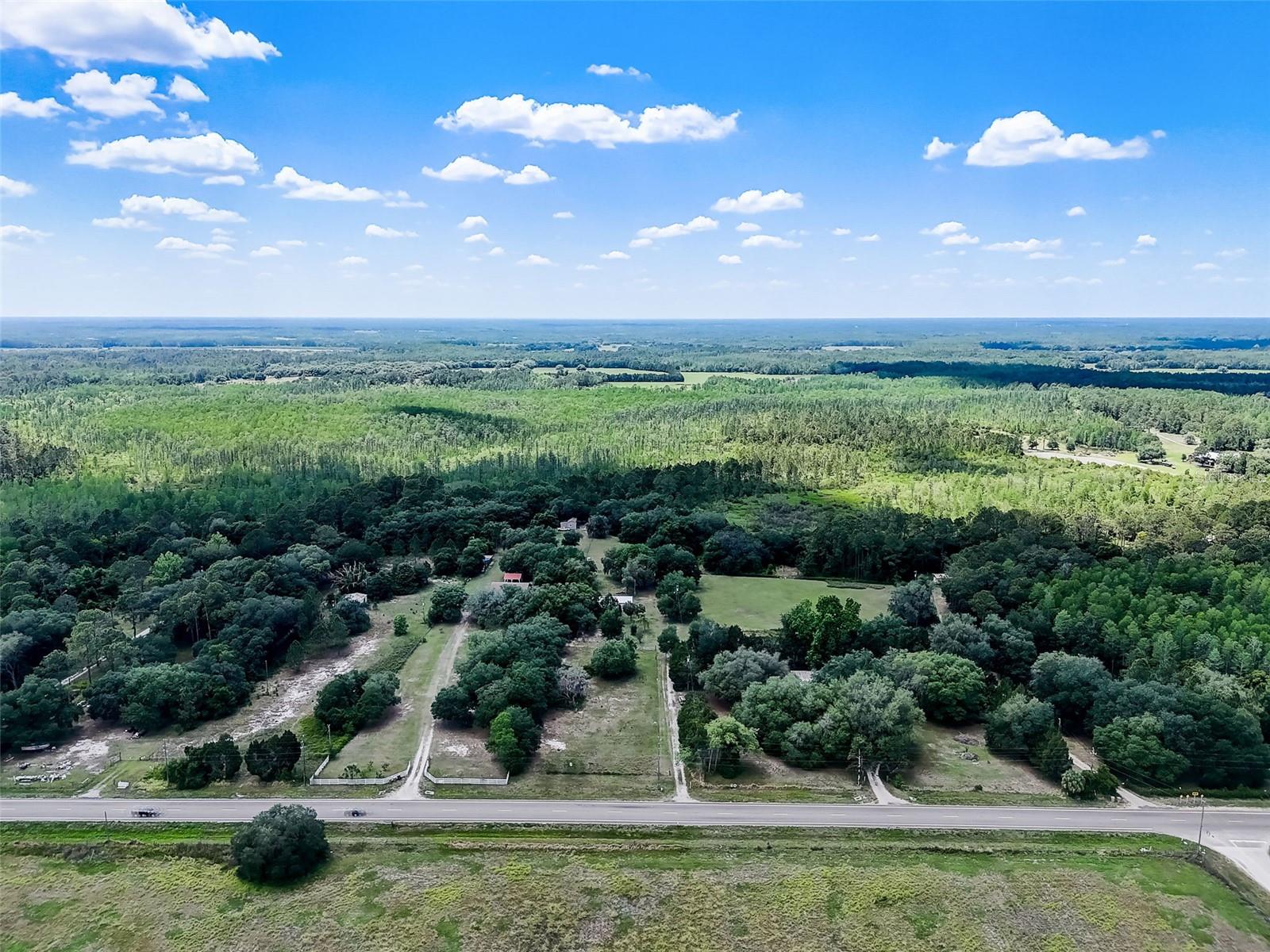 Unparalleled potential awaits on this expansive 18-acre property boasting prime highway frontage along Highway 33 in fast-growing Clermont, Florida. Free from the constraints of an HOA, this versatile acreage offers a rare blank canvas for residential, agricultural, or commercial ventures. It features a large steel shed perfect for equipment storage or a workshop, with essential utilities including septic, power, and a well already available on-site.  
The land includes a beautifully renovated double-wide mobile home currently occupied by a tenant, providing immediate rental income. Please note that the mobile home does not have a vehicle tag and cannot be financed; it can either remain as an active investment or be completely removed by the seller prior to closing. Positioned with excellent visibility and access, the acreage transitions beautifully from cleared, usable high-and-dry land to a small, picturesque patch of wooded wetlands at the very rear. Whether you dream of building a custom estate, launching a business, establishing a church, or bringing your horses and RVs, this unique property is ready to accommodate your vision.