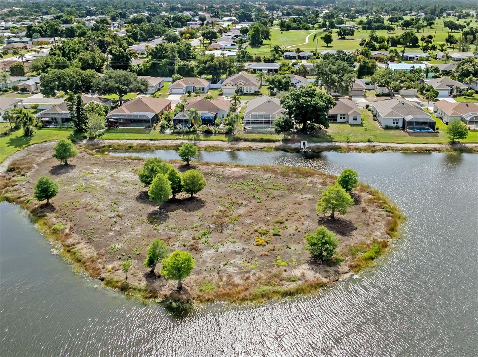 On a breathtaking lakefront homesite, this stunning three-bedroom, two-bath plus den residence offers the perfect blend of elegance, comfort and everyday convenience. From the moment you enter inside, you're welcomed by soaring volume ceilings, expansive living spaces and an abundance of natural light that fills the home through oversized windows. Designed for both relaxing and entertaining, the spacious floor plan features spacious rooms throughout, including a versatile den ideal for a home office, library or media room. The kitchen flows seamlessly into the main living areas, creating a warm and inviting atmosphere with tranquil lake views as the backdrop. Outside, enjoy your private oasis, where a sparkling pool overlooks the serene water, offering spectacular views and peaceful evenings surrounded by nature. The generous lanai provides a setting for outdoor dining, entertaining guests or simply unwinding while enjoying the picturesque scenery. The primary suite is a luxurious retreat with ample space, large windows capturing the lake views and abundant storage throughout the home, ensuring everything has its place. Additional bedrooms are thoughtfully sized to provide comfort and privacy for family and guests alike. Ideally located close to premier shopping, dining, medical facilities and A rated schools and Gulf beaches, this exceptional property combines the beauty of waterfront living with the convenience of being near everything you need. This is Florida living at its finest. Schedule your private showing today! You will be glad you did.