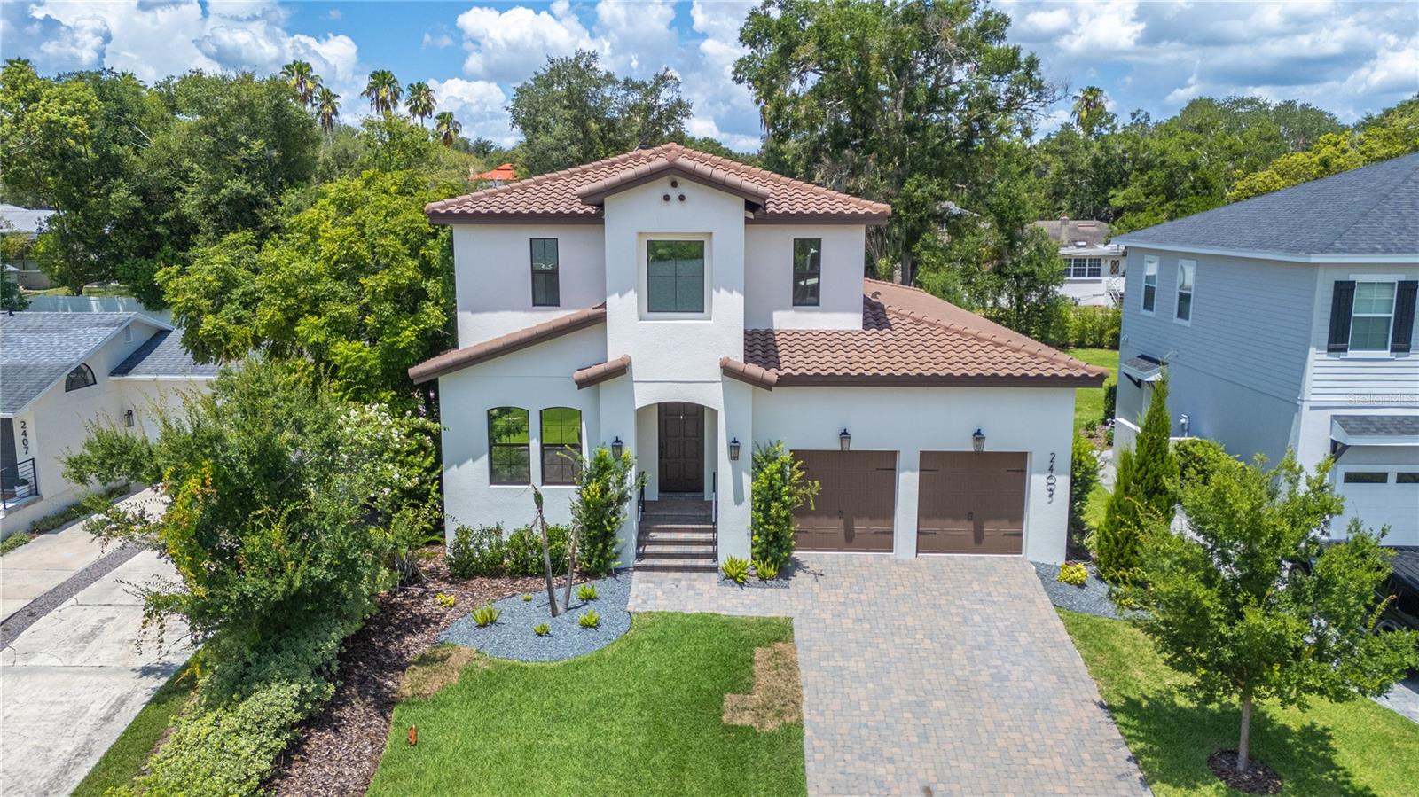 Luxury and location come together in this stunning Hulbert Homes Mediterranean-style residence just one block from Lake Hollingsworth! Built in 2023 and offering just shy of 3,000 square feet of thoughtfully designed living space, this 4-bedroom, 3-bath home also features a spacious loft and dedicated office, providing room to live, work, and entertain with ease. Venture inside to discover high ceilings and an open-concept floor plan centered around a beautifully appointed kitchen with a large quartz island, bar seating, and seamless flow into the expansive living area. The living room is anchored by a custom-built entertainment wall featuring extensive cabinetry for both display and storage, creating an elegant focal point for the home. At the front of the home, a versatile bedroom is equipped with a built-in Murphy bed and custom storage, conveniently located next to a full bath that also serves guests. The primary ensuite is tucked away off the living room and features a spacious walk-in closet with a custom California Closets system, an additional closet with built-ins, and a luxurious ensuite bath with a walk-in shower and dual-sink vanity. Upstairs, the flexible floor plan continues with two ample sized bedrooms, a large shared bathroom with tub-shower, built-in hallway cabinetry, and an open loft space that could easily be enclosed to create a fifth bedroom if desired. Also upstairs, a dedicated office overlooks the neighborhood and offers Lake Hollingsworth views, making it the perfect work-from-home retreat. Outdoor living is equally impressive in this home! The expansive 45-foot paver lanai features a wood-paneled ceiling, stone fireplace, TV wiring, and a mini bar—ideal for year-round entertaining. The fully fenced backyard offers lush landscaping and green space for relaxation, pets, or play. The home is equipped with an EV charging station in the garage and includes a generator with a direct connection to the home's electrical panel for added convenience and peace of mind. Situated on the charming brick-lined street of Derbyshire and just moments from Common Ground Park, Cleveland Heights Golf Course, and city of Lakeland tennis courts, this exceptional home offers the rare opportunity to enjoy modern living in one of Lakeland's most sought-after neighborhoods of Lake Hollingsworth!