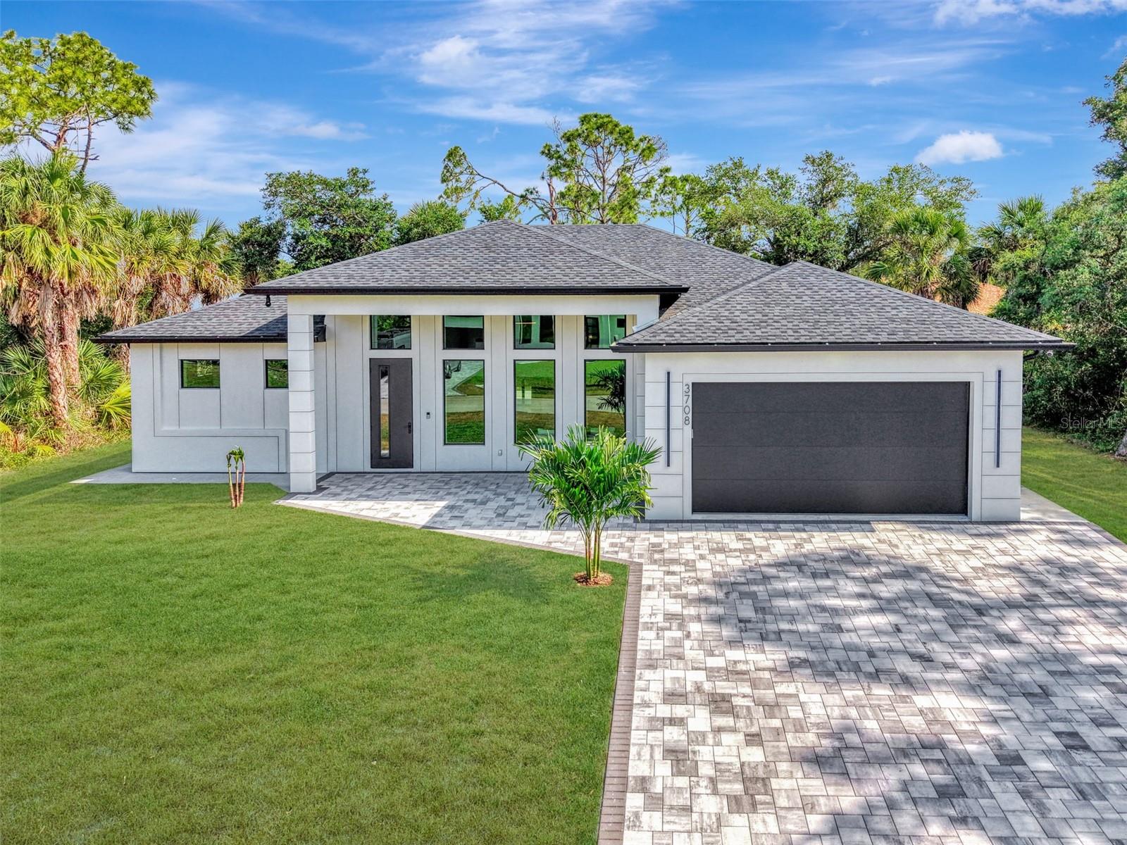 This CUSTOM HOME features every LUXURY feature you can imagine!!! As you pull into the paved driveway that was designed to fit three cars you will see the attention to every possible detail has been envisioned in designing this stunning property. The way the hurricane impact windows were designed to allow for natural light to the way the LED lights shine on the exterior. This sleek modern home has level 4 smooth finish on all the walls, adjustable LED lighting throughout, floor to ceiling tile in all the bathrooms, custom walk in closets in EVERY bedroom and 90" cabinets in the kitchen! The living room has a built in fireplace to elevate the mood, and the kitchen is every cooks dream.  It has ZLINE Autograph Addition Series appliances with gold features, pot filler, under cabinet lighting, no show cabinet in the Island and so much more!!!! The Primary bedroom has built in nightstands, massive walk in closets and you MUST SEE this primary bath! There is just too many details to describe the care and imagination it took to create something so special. Now for the laundry room, WOW!! This home is just a must see to understand the quality and attention to every single detail. The front door has a multi lock system, and the home comes with X Unified cameras all along the exterior. On the lanai there is pocket sliders, custom outdoor kitchen and bathroom which is great for entertaining.  NO detail has been missed in this stunning home!