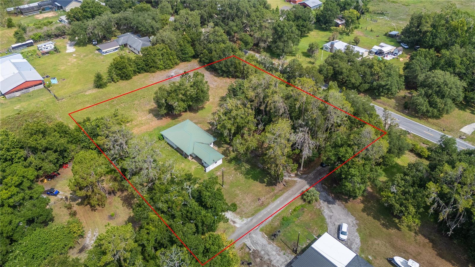 Beautifully updated ranch-style home situated on 1.75 acres in the peaceful, unincorporated area of Lakeland. Offering 3 bedrooms, 2.5 bathrooms, and 1,470 heated square feet, this home blends modern interior updates with the space and flexibility.
Step inside to find a bright, inviting layout with fresh neutral finishes, updated vinyl flooring, ceiling fans, and an eye-catching wood-beam ceiling that adds warmth and character to the main living spaces. The kitchen features neutral cabinetry, solid surface countertops, stainless steel appliances, and an eat-in dining area, creating a clean and functional space for everyday living.
The split-bedroom floor plan offers privacy, with the primary suite featuring a built-in closet and en-suite bathroom. Additional bedrooms are well-sized and versatile for guests, a home office, or hobby space.
Outside, the property truly shines. Enjoy the freedom of no HOA, plenty of open yard space, mature trees, a covered porch, patio/deck areas, fire pit, playground space, storage sheds, and a workshop — perfect for those needing extra room for tools, equipment, projects, or outdoor living. With a metal roof, block construction, well, septic, carport, and paved road access, this property offers both practicality and charm.
Conveniently located near I-4, County Line Road, and North Lakeland amenities, this home provides a quiet setting while still keeping you close to shopping, dining, schools, and commuter routes. Whether you are looking for space to spread out, room for hobbies, or a move-in-ready home with acreage, this property is a must-see.