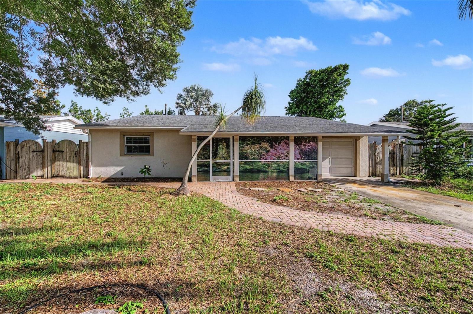 Space, comfort, and a great layout come together in this 4-bedroom, 3-bath home offering over 2,000 square feet in a charming St. Petersburg neighborhood. A spacious screened front porch provides the perfect place to enjoy your morning coffee or unwind at the end of the day. Inside, the living room opens to the kitchen that features granite countertops, stainless steel appliances, and a convenient butler's pantry/coffee bar with additional cabinetry for extra storage. The oversized family room is a standout, featuring vaulted ceilings and a cozy corner fireplace that make this space feel open and inviting. Fresh paint throughout and brand-new carpet in the bedrooms give the home a fresh, move-in-ready feel. The generous primary suite offers a large walk-in closet and an ensuite bath with a spacious walk-in shower highlighted by a charming stained-glass window that adds a touch of personality.Offering plenty of room to spread out, several thoughtful updates, and the opportunity to add your own finishing touches, this home is ready for its next owners to make it their own.