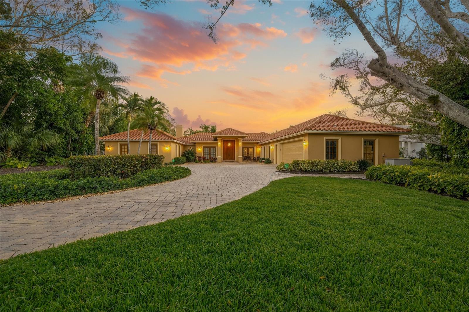 A timeless expression of Spanish Mediterranean elegance set along tranquil waterfront. Welcome to 1634 N Lodge Drive.
Perfectly positioned in one of Sarasota’s most coveted neighborhoods, this exceptional canal-front estate blends old-world architectural character with refined, eclectic finishes and an unmistakable sense of luxury. From the moment you arrive, the circular paver driveway, clay tile rooflines, arched entryways, and lush tropical landscaping create a grand yet inviting first impression.

Inside, the home unfolds as a warm, richly layered retreat. Natural stone flooring, custom woodwork, and thoughtfully curated details give each space depth and character, while expansive windows and French doors flood the interiors with natural light. Multiple living areas flow effortlessly, offering both intimate gathering spaces and elegant rooms designed for entertaining.

The chef’s kitchen is a statement of craftsmanship, featuring custom cabinetry, stone countertops, professional-grade appliances, and a dramatic range hood that anchors the space. Adjacent dining and living areas connect seamlessly to the outdoors, allowing the home to live beautifully both inside and out. A temperature-controlled wine cellar adds a rare and luxurious touch, perfect for collectors and entertainers alike.

The primary suite is a private sanctuary, offering serene water views, direct access to the lanai, and a spa-inspired bath adorned with stone finishes, custom vanities, and timeless Mediterranean flair. Guest suites are equally inviting, each thoughtfully designed with privacy, comfort, and architectural charm in mind.

Outdoor living is nothing short of spectacular. The screened lanai surrounds a resort-style pool, framed by covered seating areas with wood-paneled ceilings and ceiling fans—ideal for alfresco dining, relaxed afternoons, or sunset evenings. Beyond the pool, the home has a brand new generator and the property opens to a private waterfront setting, complete with a dock along the canal, offering peaceful water views and the opportunity to enjoy boating, kayaking, or simply soaking in Sarasota’s coastal ambiance.

Aerial imagery highlights the home’s prime location, mature landscaping, and close proximity to Sarasota Bay, downtown Sarasota, world-renowned beaches, fine dining, shopping, and cultural attractions.

Rich in character, anchored in craftsmanship, and perfectly positioned on the water, 1634 N Lodge Drive is more than a home—it is a legacy property offering the very best of Sarasota’s waterfront lifestyle.