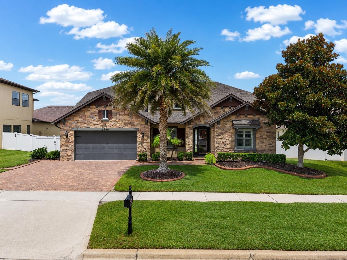 Perfectly situated in the prestigious gated community of Hunters Run in Clermont, this impressive one-story residence offers the space, comfort, and lifestyle today’s buyers are looking for. Built in 2015 and offering over 3,100 square feet of living space, this thoughtfully designed home features 4 bedrooms, 3 full bathrooms, a flexible three-way split floor plan, and a 3-car garage. From the moment you arrive, the home makes a strong first impression with its upgraded stone-accented elevation, attractive curb appeal, brick paver driveway, and oversized homesite with a fully fenced backyard.
Inside, the home delivers an open and functional layout with high ceilings, abundant natural light, and generous living spaces ideal for both everyday living and entertaining. The gourmet kitchen is a true centerpiece, featuring granite countertops, upgraded cabinetry, stainless steel appliances, gas cooking, double ovens, a large island, custom backsplash, and excellent connection to the main living areas. Additional interior highlights include a dedicated office/den with French doors, split bedrooms for added privacy, a spacious primary suite, tile flooring throughout the main living areas, ceiling fans, upgraded lighting, and a covered lanai overlooking the backyard.
The sellers have made numerous improvements during their ownership, including a new roof in 2024, a huge expanded covered lanai in 2024, garage ceiling racks in 2022, ADT security in 2017, a home sound system in 2020, plantation shutters in 2021, tinted windows in 2021, a water softener in 2020, and wider driveway improvements. Residents of Hunters Run enjoy access to the community’s resort-style zero-entry pool, gated entrances, playground, brick-paver walkways, and beautifully maintained neighborhood setting.
Located among Clermont’s iconic rolling hills, Hunters Run is known for its oversized homesites, attractive streetscapes, and family-friendly atmosphere. Beyond the gates, you are just minutes from the Clermont Chain of Lakes, shopping and dining at Winter Garden Village, major medical facilities, schools, commuter routes, and the growing lifestyle amenities that make Clermont one of Central Florida’s most desirable places to live.