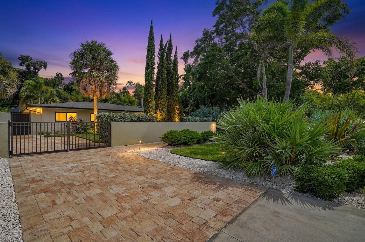 Set behind a privacy wall with lush, mature tropical landscaping, this recently renovated home blends Florida living with warm, globally-inspired design. The residence sits just steps from Sapphire Shores Park, a neighborhood gem known for stunning sunset water views, a laid-back yoga-on-the-lawn scene, a kids' playground, and easy waterside fishing.
The main living space centers on a wood-tile fireplace wall with a built-in window bench, flowing openly into the kitchen and dining area. Wide impact-glass windows fill the space with natural light.
The home offers three bedrooms and two bathrooms, plus a private in-law suite with its own full bathroom, giving it real versatility for multigenerational living, guests, or rental income potential.
Outside, a screened, covered lanai wraps a paver-decked pool, complete with a built-in outdoor kitchen (grill, sink, refrigerator, prep space) and multiple lounge and dining areas. The perimeter wall and dense palm landscaping give the whole property a private, resort-like feel from the moment guests arrive.
Just seconds from the water and the park, this is coastal Sarasota living at its most livable.
Recently renovated, concrete construction, impact-glass windows, a 2020 roof, and a 2024 AC system: this home is fully hurricane-ready, with no major expenses to prepare for years to come.