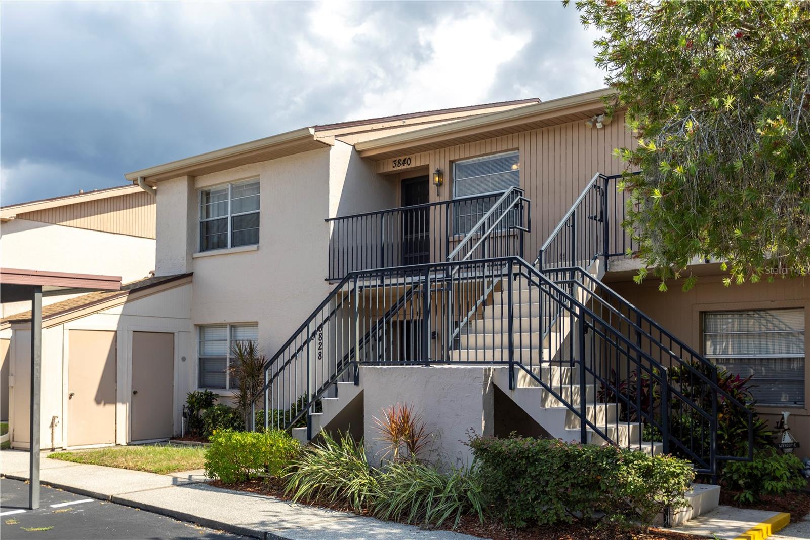 WATERFRONT LIVING IN A BEAUTIFUL 55+ COMMUNITY!
Welcome to easy Florida living in this spacious and well-maintained second-floor condo offering peaceful water views, natural light, and nearly 1,115 sq ft of comfortable living space. This 2-bedroom, 1-bath residence combines comfort, privacy, and convenience in one of Holiday’s desirable 55+ communities.
Being on the second floor comes with some wonderful advantages — enjoy elevated lake views, added privacy, more natural light, and peace of mind with no foot traffic directly outside your windows or patio. One of the standout features is the oversized Florida room offering over 150 sq ft of additional living space — large enough to create a cozy sitting area, reading nook, home office, or even an extra entertaining space while enjoying the serene water and fountain views.
Inside, you’ll find a spacious layout with a large living and dining area, an eat-in kitchen nook, updated flooring in the kitchen nook and patio area, and a beautifully updated shower enclosure in the bathroom. The condo also includes in-unit laundry with newer Samsung washer and dryer for everyday convenience. A BRAND NEW AC was installed in 2025, and the building roof was replaced in 2019. This unit also comes with its own private storage shed conveniently located downstairs beneath the unit — perfect for beach gear, tools, bicycles, or seasonal items.
The community offers fantastic amenities including a heated pool, clubhouse, pickleball court, plenty of guest parking, and covered assigned parking.
The HOA fee covers water, sewer, trash, cable, internet, exterior maintenance, and more — leaving you with very little to worry about besides your electric bill. Conveniently located near shopping, restaurants, beaches, golf courses, and the famous Tarpon Springs Sponge Docks.

Move-in ready and full of charm — come enjoy the relaxed Florida lifestyle you’ve been waiting for!