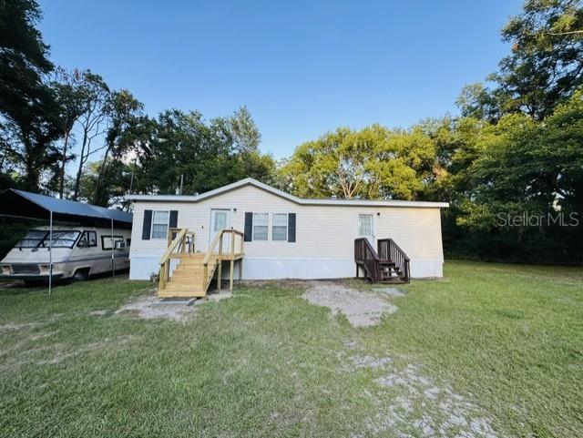 One or more photo(s) has been virtually staged. Country living close to town! NO HOA! This 3-bedroom, 2-bath fixer-upper sits on 1.25 acres in the heart of the Withlacoochee Forest, offering room to spread out, bring your toys, and enjoy nature at its best. With recent updates such as: Roof 2025 with 50 year shingles with a warranty that is transferable, HWH 2024, Outside A/C 2025, New Sliding Glass Doors, Double pane windows, Skirting replaced, New deck and steps at the front door, this property is ready for your finishing touches.  This home features an RV hookup, streetlight, fenced yard, and plenty of space for a garden, animals, outdoor living, or your own homestead lifestyle. Raise your family, grow your food, and enjoy the peace of country living while still being close to everyday conveniences. You can walk to hunt or fish. Enjoy the many visitors of deer, all different types of birds, and even wild turkey in your yard. Located with quick access to I-75, this property is centrally positioned about one hour from Tampa, Orlando, and the West Coast beaches. You’ll also be near shopping, dining, community events, the Webster Flea Market, motocross park, fishing, nature trails, and horse trails. Bring your family, toys, horses, and animals and make your vision come alive and make this country property your own. Schedule your tour today!