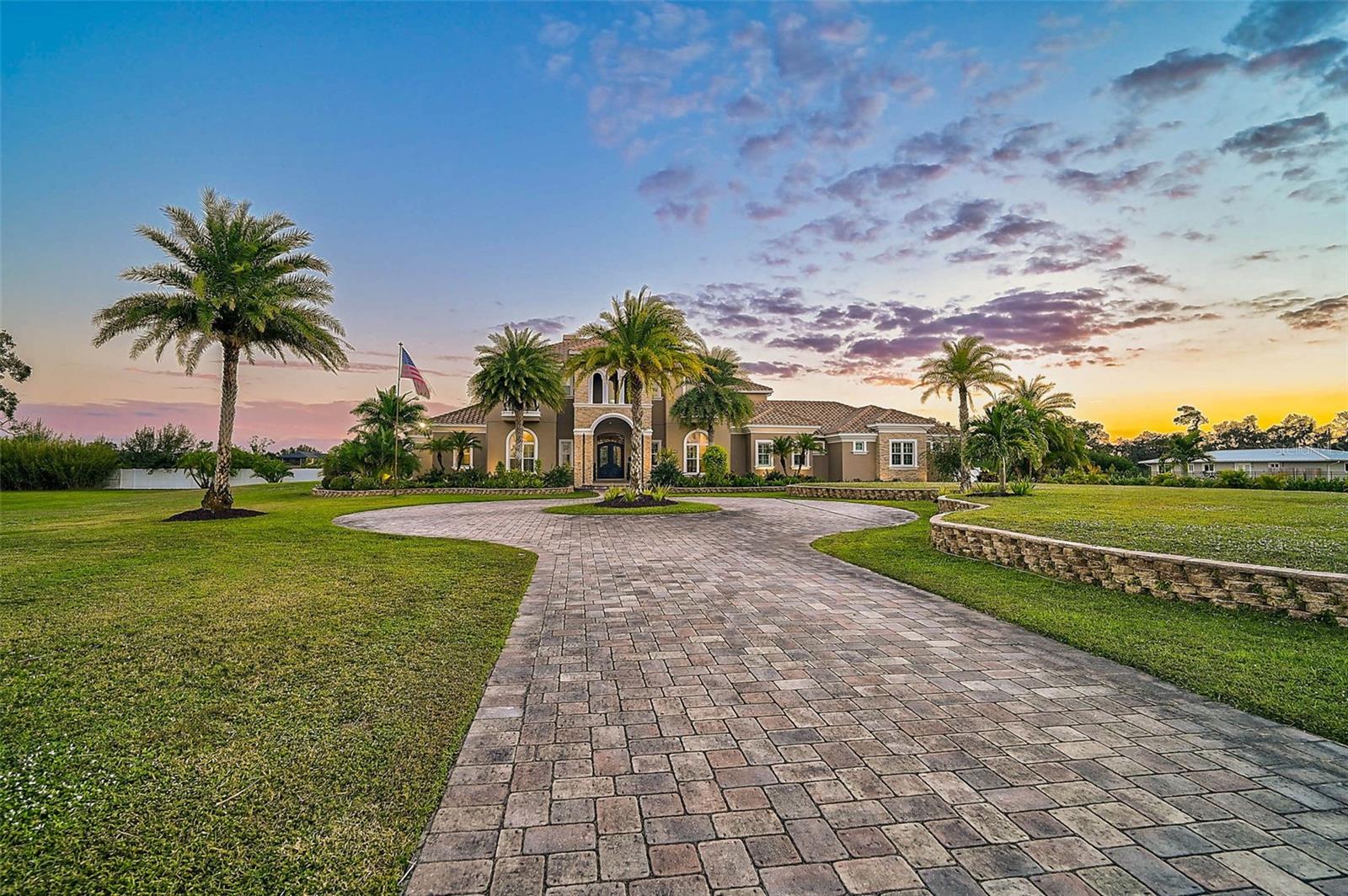 **EXQUISITE, CUSTOM-BUILT (2018) ESTATE SITUATED ON 6.80 ACRES OFFERS THE UTMOST IN LUXURY LIVING AND ENTERTAINING** Behind the Private, iron gate entrance, you will find a Magnificent Residence with its Spacious 6350sf floorplan boasting 5 En Suite Bedrooms + Office, 4-Car Garage and numerous indoor and outdoor venues for Entertaining your loved ones!  Premium features abound throughout this meticulously detailed residence, including 26ft Soaring Ceilings, winding staircase, stone gas fireplace, climate-controlled wine storage room, bar area, additional Bonus Room and Bar on the second level accompanied by a charming Library and impressive Home Theater / Media Room.  The striking Chef’s Kitchen entails exotic stone counters, custom hardwood cabinetry, premium appliances including Thermador and Wolf, large walk-in pantry, etc. The Elegant Primary Suite features a private seating area with serene pool views, custom walk-in closets and expansive primary bath with separate sinks, soaking tub and custom-tiled shower.  Enjoy a quintessential Florida lifestyle with a Resort-style, outdoor oasis featuring a saltwater Pool with swim-up bar, adjacent casita, Outdoor Kitchen/Grilling area, lounge deck, and more!  The manicured grounds entail wonderful natural highlights including a large, palm tree-lined, stocked fishing pond, gazebo with bridge over a lovely koi pond, elevated garden, basketball court, etc.  Multiple outbuildings include a (1) separate Garage Apartment with Full Bath, Kitchenette, covered parking, (2) well-equipped RV garage with full electrical package, etc.  Advance, Reverse Osmosis technology delivering over 4,000 gallons of pristine water daily from a 2500-gallon primary tank and two secondary 500-gallon tanks, equipped with filters, offers a complete solution for your water purification needs.  LOCATION! LOCATION!! Adjacent to Twin Lakes Park with its many recreational venues and Easy Access to Nearby Interstate-75 and SR72, area Beaches including #1-rated Siesta Beach, Shopping, Downtown Sarasota cultural venues, and all that Florida’s Gulf Coast Living has to offer.  **Enjoy Viewing the 3D VIRTUAL TOUR and AERIAL VIDEO**