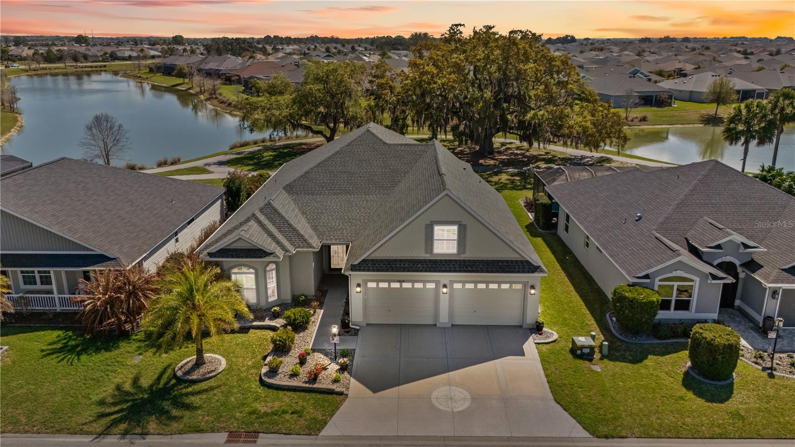 One or more photo(s) has been virtually staged. Rare Sarasota Premier model featuring an extraordinary 4-car garage measuring 29.9 x 40, a feature rarely found in The Villages and ideal for car enthusiasts, golf carts, storage, or a workshop. The home also includes a large bonus room (16.9 x 39.7) perfect for a game room, hobby space, studio, or additional living area. The driveway features a durable decorative concrete finish, while the garage flooring is epoxy coated for easy maintenance. Interior upgrades include quartz countertops in the kitchen and baths, tile backsplash, solid cherry cabinetry with soft-close doors and drawers, plantation shutters, tray ceilings, rounded drywall corners, and double-pane Low-E windows. All bedrooms feature custom California Closet systems for exceptional organization and storage. Enjoy a beautiful double water view from this well-appointed home. The property also conveys with the remainder of The Villages 10-year structural warranty, the remainder of the HVAC 10-year parts warranty, and a 30-year architectural shingle roof warranty, all transferable for nominal fees.