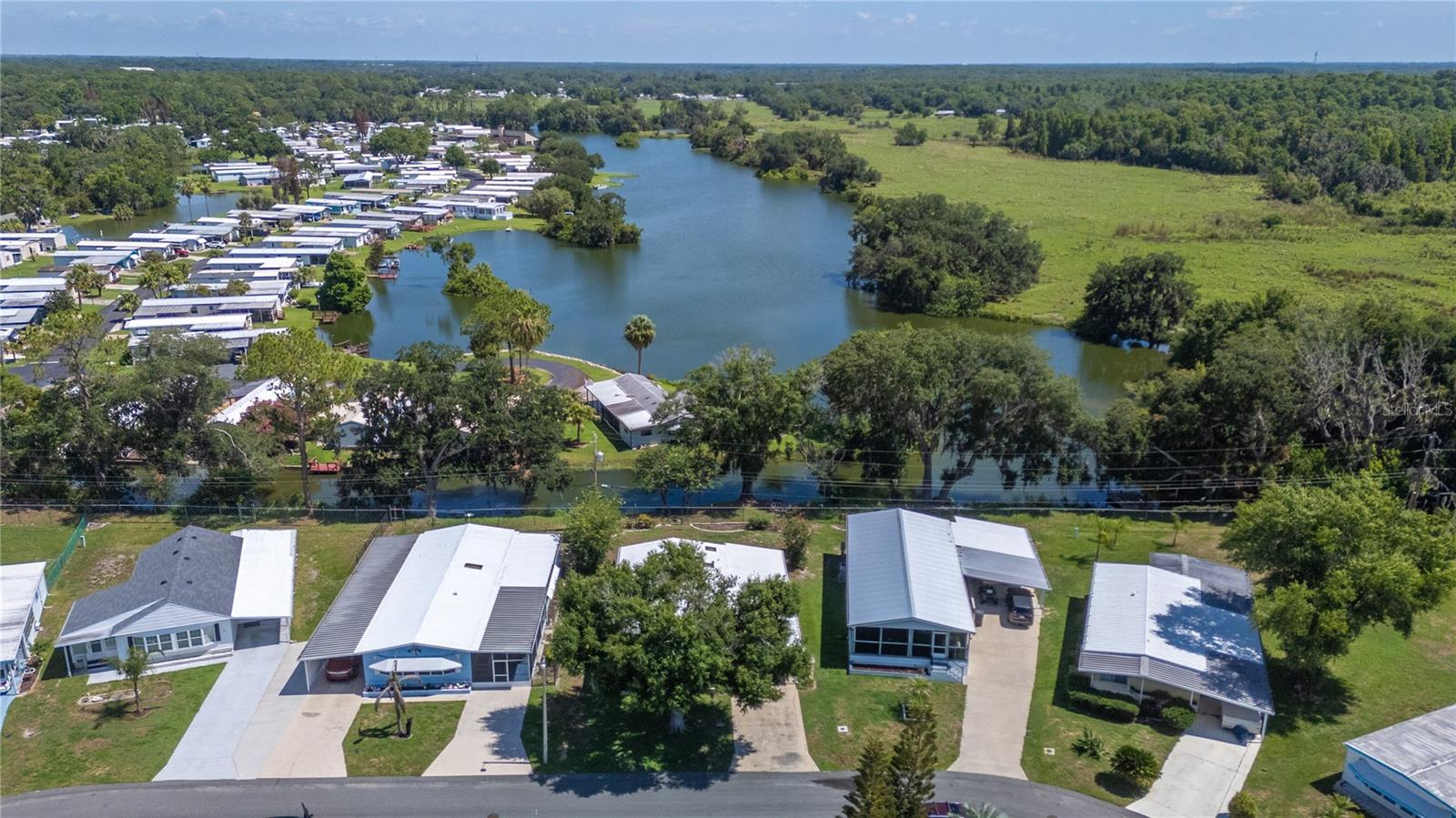 Picture morning coffee out back, watching the water move along the canal, the golf cart ready for a loop to the clubhouse. This is one of the few homes in Citrus Woods that sits right on a finger canal off Anglers Lake, with its own dock and no direct rear neighbors.

If you're looking for something spacious, you've found it! A big L-shaped kitchen with room to cook and gather, an eat-in space plus a formal dining room, and a separate office nook. The Florida room adapts to you, with a seating area, the laundry, and a flexible bonus room that has its own entrance. Handrails are in both baths and a wheelchair lift make daily living easier. It comes partially furnished, so you can settle in sooner.

YOU OWN THE LAND! The HOA runs just $710/year and covers a heated pool, shuffleboard, clubhouse, library, and nighttime security through the Sheriff's Office. Pets are welcome.

Roof comes with a 10-year warranty | HVAC is 2026 | Newer windows | Re-plumbed | Leaf-guard gutters | Refrigerator 2023 | Toilets 2024. The golf cart stays.

If life on the water in a 55+ community sounds like your next chapter, come see it in person!
