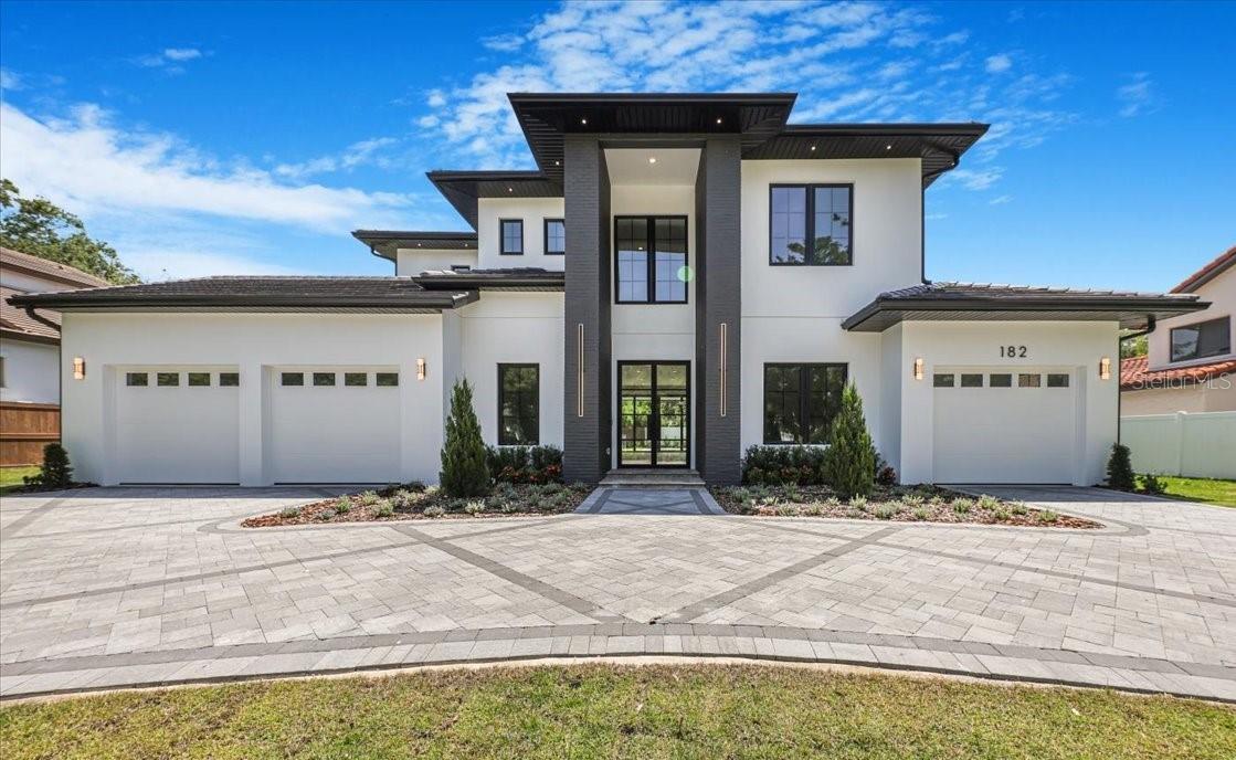 Welcome to a stunning new home positioned near Windsong and the AdventHealth Hospital. This extraordinary property boasts 4,812 square feet under AC. The stately manner is thoughtfully designed with four commodious bedrooms and five full-size bathrooms. Additionally, it features an expansive three-car garage complemented by an impressively constructed circular paver driveway. 
The first floor showcases lofty 11.4-foot ceilings, while the second floor features equally impressive 10-foot ceilings. A plentiful array of windows and numerous sliding doors augment the home's overall charm by inviting a flood of natural sunlight. A medley of Lutron dimmers and smart switches grants effortless convenience at your fingertips.
You will be warmly welcomed by a majestic steel glass hurricane impact door. Upon setting foot into this marvelous residence, one is instantly greeted by the glow of Oak wood floors, thoughtfully woven throughout each corner of the abode. Well-appointed Walnut and Oak wall panels add an unparalleled layer of understated luxury to this remarkable home.
The kitchen is a visual treat with an expansive waterfall island dominating the space. Floor-to-ceiling cabinets deliver abundant storage while the gleaming Quartz countertops exhibit both beauty and durability. To add to its grandeur, a matching Quartz backsplash extends all the way to touch the ceiling, seamlessly melding simplicity with luxury.
The kitchen comes fully equipped with all Thermador appliances, ready to cater to your every culinary need. This suite of top-tier appliances includes a grand 72-inch combo Freezer/Wine Tower/Fridge, a natural gas 48-inch Range with a steam oven guarantees an enjoyable cooking experience each time. Two fully equipped laundry rooms, one located on each floor.  The master bedroom features an expansive sliding glass door leading you directly to the tranquillity of the sprawling backyard.
The master bathroom is a serene, spa-like haven designed with luxurious Italian tiles, a natural stone accent wall that lends an air of sophistication. The floating cabinets add to the modern aesthetic and are enhanced by the backlit marble countertops, radiating a soft glow, adding to the relaxing atmosphere.
The second floor boasts 3 well-appointed bedrooms and corresponding bathrooms, each outfitted with Marble countertops that enhance their plush ambience. Uniquely offering versatility, a large flex area graces this floor, which could be customized according to your liking or needs. Ensuring fun entertainment spaces within the confines of your home exists a game room too, catering to all age groups! The special feature is an in-built wet bar complemented by Cristallo Quartzite counters and custom cabinetry, thus serving as an ideal indoor party venue. As an extension of indoor living space, the outdoors is a sizeable terrace accented with contemporary glass railings.
Yes, the backyard is a true oasis in this property. A large covered lanai provides ample space for relaxation or outdoor dining. The summer kitchen features state-of-the-art appliances to assist in making your entertaining dreams come true. No luxury home would be complete without a pool, and this one comes with a gas-heated saltwater pool and a spa. A full pool Bathroom with a Steam Shower. Travertine pavers enhance the overall appeal.
In conclusion, the home exhibits a smooth blend of advanced technology and high-end finishes, promising a luxurious living experience!