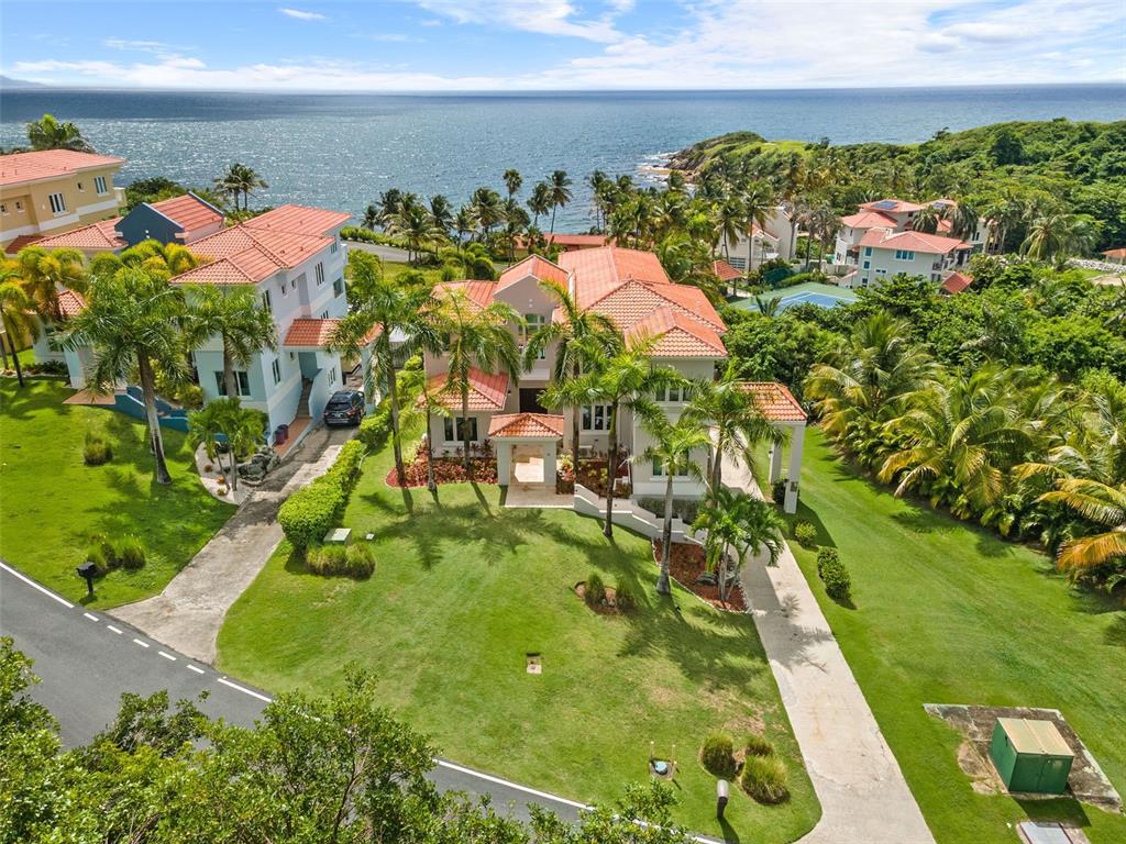 This modern cliff-side estate home with awe-inspiring ocean views is for sale in the renowned Palmas del Mar Resort. Upon entering the home, you are greeted by a grand double height ceiling with a wall of glass that brings in natural light and provides stunning views of the palm trees and ocean beyond. The main level features a remodeled open kitchen with quartz countertops, a window over the sink with views of swaying palm trees, and a living room with wet bar that opens to a large balcony overlooking the ocean and pool. There is also a family room and formal dining room on this level. While a bedroom with an ensuite bathroom, office, and half bathroom complete this floor.

Upstairs you will find three additional bedrooms all with ensuite bathrooms as well as the master suite. The master suite features beautiful ocean views from the private balcony and from the bed itself. The spacious master bath has double sinks, a walk-in shower, and a walk-in closet. There is also a large laundry room on this level for your convenience.

The lower level of this magnificent home houses a family room as well as an additional bedroom with an ensuite bathroom. This would be perfect for guests or extended family visiting on vacation. 

Outdoors you will find a lovely pool, hot tub and patio area with travertine flooring, gazebo, and plenty of space for entertaining or simply relaxing in the sun. The incredible ocean views and dramatic cliff-side setting provide the perfect backdrop for this idyllic home. There is also an outdoor BBQ area as well as its own pool bathroom – making it easy to take care of all your needs without ever having to leave your backyard oasis! 

With top-of-the-line windows and doors that are thermally efficient and hurricane resistant this home is built to withstand anything Mother Nature can throw at it. The estate also comes with a generator – ensuring you are never without power, even during the most severe weather conditions.

Walking distance to the beach and access to all the amenities that Palmas del Mar Resort has to offer, this is truly a one-of-a-kind opportunity. Don’t miss your chance to own a piece of paradise!

PALMAS DEL MAR RESORT
Palmas Del Mar is a world-renowned resort community that offers a wide range of amenities to its residents that are just a golf cart ride away. From championship golf courses to, tennis, equestrian center, beach club and a world-class marina, there is something for everyone to enjoy. There are also several restaurants, retail stores, and a grocery store located within the community. And with five miles of coastline, including two miles of beach, there are plenty of opportunities to enjoy the outdoors. Families will appreciate the Palmas Academy, which offers an English language education from pre-kindergarten to 12th grade. With so much to offer, it's no wonder Palmas Del Mar is one of the most sought-after communities in Puerto Rico.