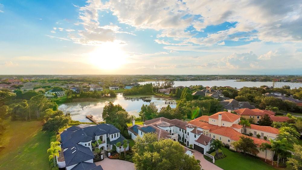 Get ready to enjoy the lake lifestyle in your custom estate poised on a cul-de-sac lot with 110 feet of pristine shoreline on Lake Burden. Recently underwent a $1 million remodel. This masterpiece of a home has it all with 5 bedrooms, 5.5 bathrooms, spacious great room, office, and a large 5 car garage! Your timeless Mediterranean home with contemporary finishes was designed to enjoy the breathtaking panoramic views of sunsets and Disney fireworks over Lake Burden with the utmost comfort and privacy. The grand façade has its own gated courtyard includes lush tropical landscaping complimented with a long driveway, balcony, and large custom double entry door. Upon entry you will immediately notice 12’ soaring high ceilings in the foyer with chic porcelain floors throughout. Sit back, relax, and take in your beautiful lake views from the great room which is open to the kitchen and casual dining space. The chef’s kitchen is a dream come true with a large center island, breakfast bar seating, marble backsplash, Viking refrigerator and dishwasher, Dacor 6 burner range with a vented hood and a walk-in pantry. The elegant dining room is perfect for those formal occasions with its own private courtyard and temperature controlled 1,000+ bottle wine cellar. Work from home in peace with your own office away from the living areas. The primary suite has its own seating area with amazing lake views including two large built-in walk-in closets, spa like bathroom including a glass shower, tub, and dual vanities. All secondary bedrooms are spacious en-suites with plenty of closet space. Relax and enjoy captivating lake views within the serenity of the expansive outdoor living area that is fully screened with your heated pool and water features with premium stone deck pavers. The covered lanai includes an amazing fully equipped summer kitchen for those perfect summer barbeques and get-togethers with loved ones. Gather around the massive sunken firepit for those beautiful star gazing nights. The wooden dock includes a jet ski lift to enjoy all 129 acres of Lake Burden. Your home was built by award-winning builder Campbell Custom Homes and features one-of-a-kind finishes throughout. Additionally, Keene’s Pointe is a 24-hour guard gated community, includes plenty of parks, playgrounds, with access to The Butler Chain of Lakes, The Golden Bear Country Club with amenities that include a gym, pool, golf, tennis courts, and neighborhood boat/RV storage. Close to Orlando’s best attractions including Walt Disney World, shopping, and “A” schools including Windermere Elementary, Bridgewater Middle, and the newer Windermere High School. Don’t miss out on this extraordinary lakefront property. Be sure to click on the virtual tour links.