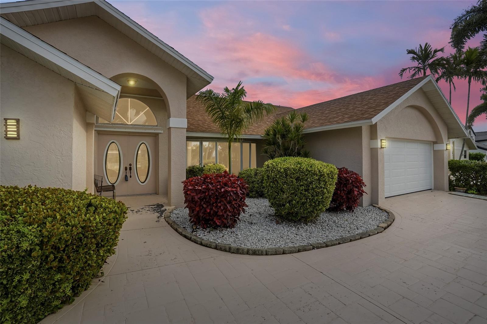 DIRECT GULF ACCESS, MINUTES TO OPEN WATER, POOL HOME, AND WALKING DISTANCE TO CAPE HARBOUR Welcome to your slice of waterfront paradise with NO BRIDGES and direct Gulf access, perfectly positioned on a wide canal and just minutes by boat to open water. This prime location offers the best of both worlds with a short walk to Cape Harbour’s dining, shopping, and marina lifestyle, as well as nearby grocery stores, restaurants, and everyday conveniences. This custom built, one owner home offers 2,674 square feet under air with 3 bedrooms, 2 bathrooms plus a separate pool bath, offering both space and functionality . A circular driveway, lush white rock landscaping, and double entry French doors create a stunning first impression. Inside, you will find soaring and vaulted ceilings, tile flooring throughout, and an open, light filled layout featuring two spacious living areas, a real stone wood burning fireplace, and two dining spaces perfect for hosting or creating a cozy breakfast nook. The updated kitchen showcases quartz and granite style countertops, white appliances, an extra large refrigerator and freezer, electric KitchenAid cooktop, and double wall ovens, making it ideal for everyday living and entertaining. The primary suite is a private retreat with sliding doors to the lanai, two walk in closets, and a spa like bathroom featuring dual sinks, a makeup vanity, oversized shower, and a jetted soaking tub. Function meets convenience with a huge laundry room complete with quartz countertops, upper and lower cabinetry, backsplash, sink, and newer Whirlpool washer and dryer. The finished garage includes built in cabinets and workbenches for additional storage and functionality. Designed for true indoor outdoor living, pocket sliding glass doors open the home completely to the covered lanai, where you will find electric fabric shutters, a newly installed pool enclosure, a pebble finished patio, outdoor shower, and a dedicated pool bath for seamless entertaining. Additional upgrades include a newer roof completed in 2023, updated two zone AC systems, fresh interior paint, updated guest bathroom, and new carpet in guest bedrooms. The home is fully equipped with extensive hurricane protection including shutters and accordion panels for added peace of mind. With no history of flooding, a concrete cantilever dock already in place, and space to design your ideal lift or boating setup, this property is truly a boater’s dream and a rare opportunity to create your ideal waterfront lifestyle in one of Southwest Cape Coral’s most desirable locations.