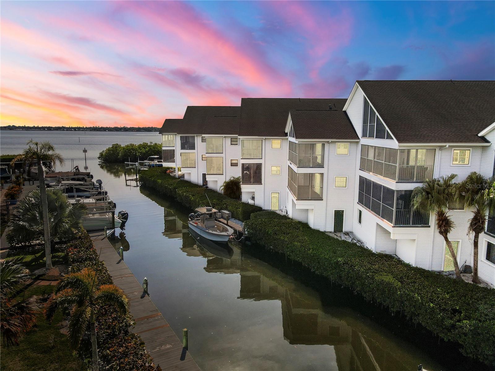 Enjoy the best of Florida waterfront living in this beautifully maintained condominium community featuring direct water access, private boat docks, and resort-style amenities. Nestled along a protected canal with open water views beyond, this residence offers an exceptional opportunity for boating enthusiasts and those seeking a relaxed coastal lifestyle.
Inside, the light-filled living area showcases attractive wood-look flooring, neutral finishes, and large sliding glass doors that open to a private screened balcony overlooking the marina and waterways. The open, airy layout provides a welcoming space for everyday living and entertaining while capturing tranquil waterfront views.
Residents enjoy access to a waterfront pool, clubhouse, tennis courts, and well-maintained marina facilities, creating a true resort-style atmosphere. The community's distinctive architecture, mature landscaping, and direct boating access make it a standout destination for seasonal or year-round living.
Whether you're looking for a permanent residence, vacation retreat, or investment property, this waterfront gem offers an exceptional combination of comfort, convenience, and coastal charm.